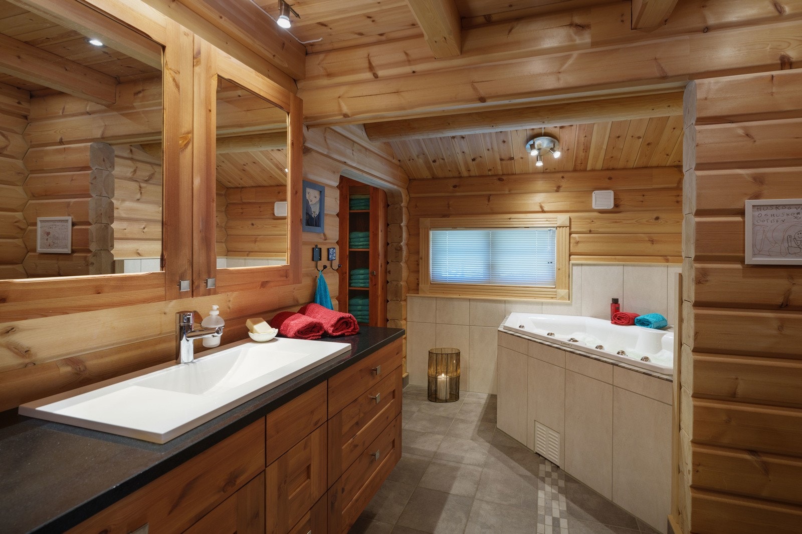 På badet i første er det god oppbevaringsplass i en tidsmessig, bred servantinnredning, og i tillegg til et vegghengt toalett har badet en dusjnisje og et hjørnebadekar med boblefunksjon. Galleribilde