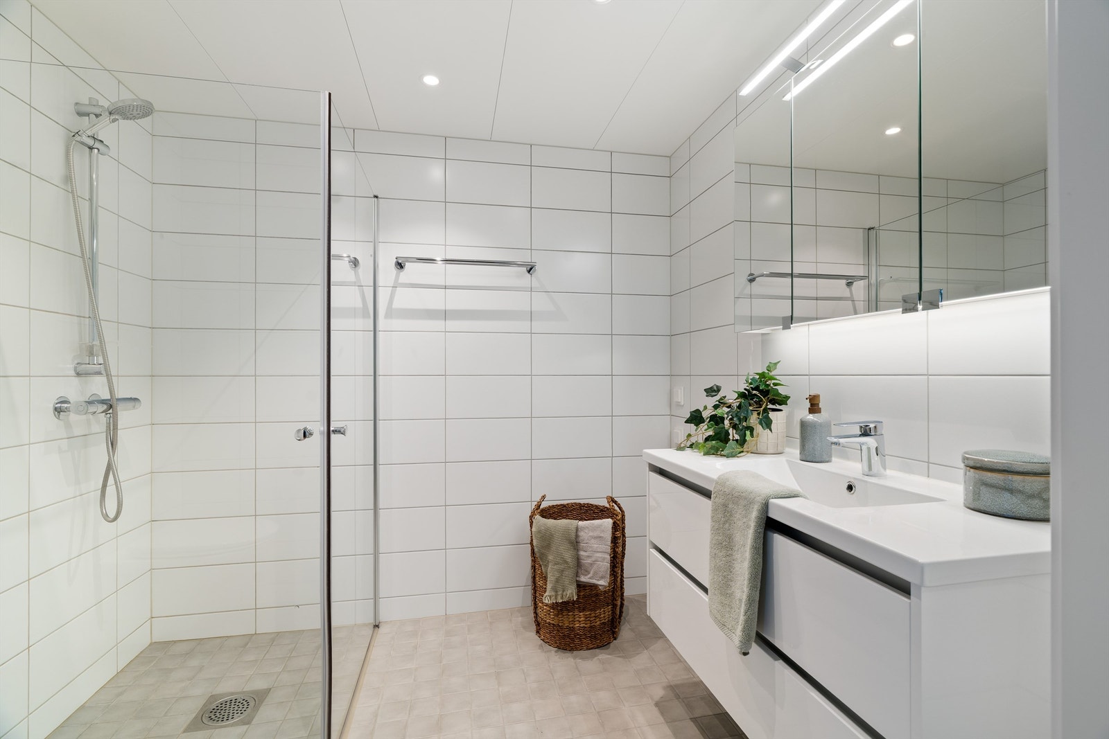 Badet på 4 kvm er pent flislagt med lyse fliser, varme i gulvet, downlights i himling og opplegg for vaskemaskin. Galleribilde