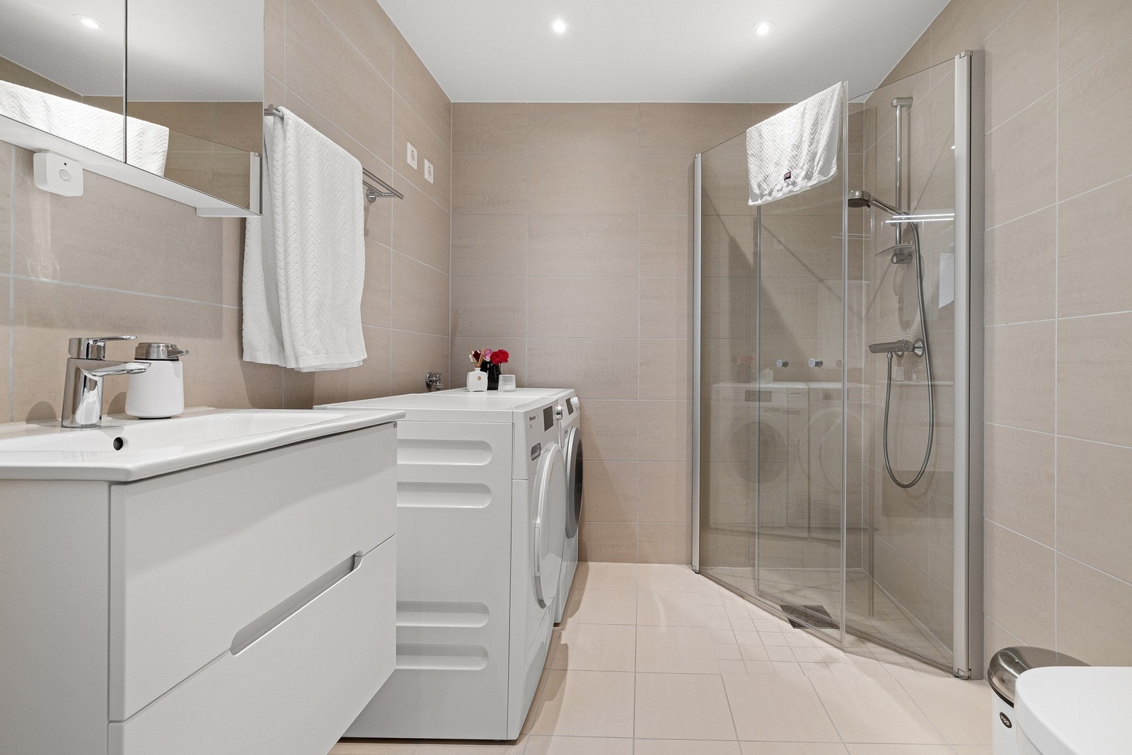 Et lekkert, flislagt baderom fra 2020. Opplegg for både vaskemaskin og tørketrommel. Galleribilde