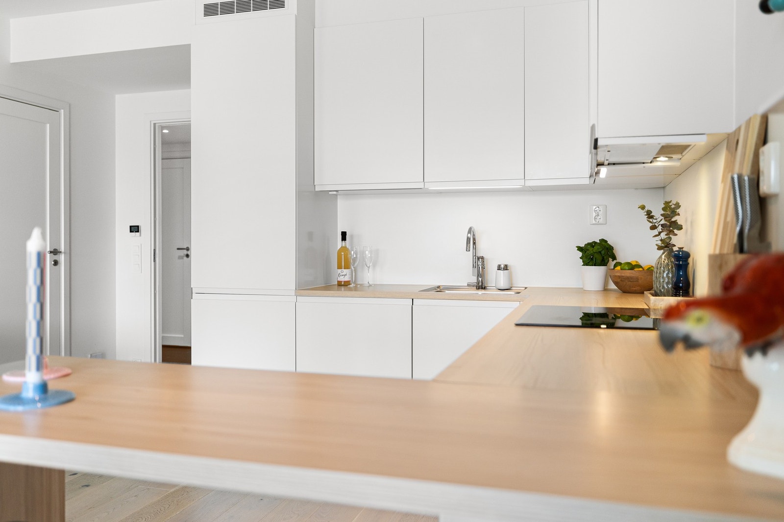 Moderne og stilren innredning med mye skap og benkeplass og integrerte hvitevarer. Galleribilde