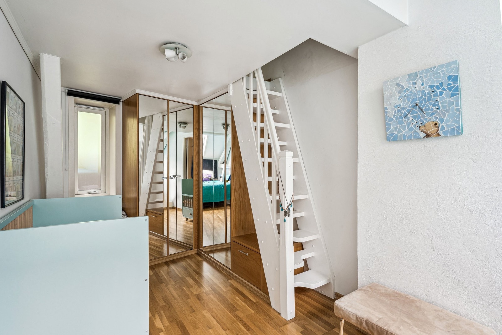 Soverommet er innredet med garderobeskap og trappeadkomst til en stor og praktisk hems med vinduer. Galleribilde