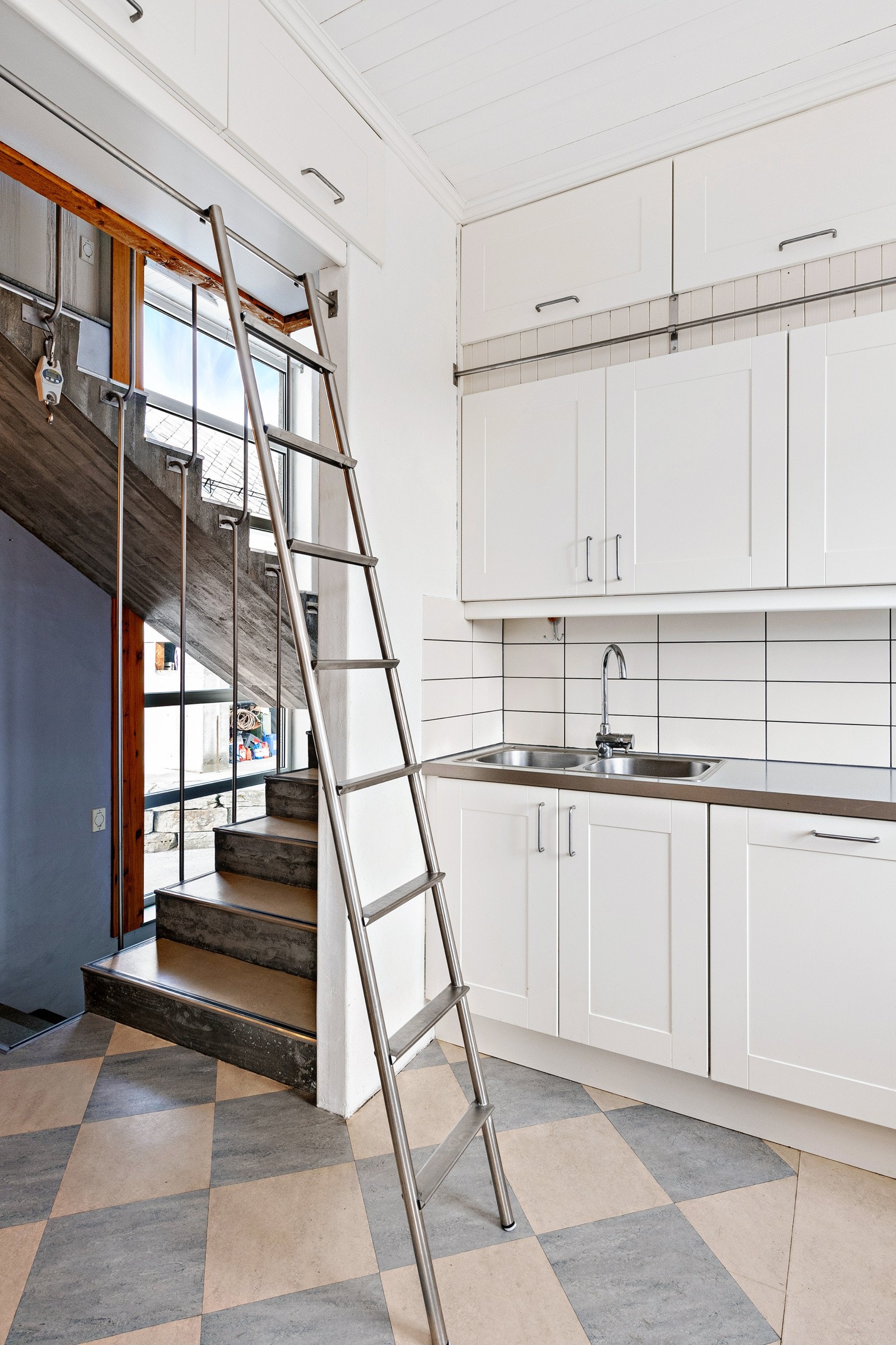 Legg merke til skapene helt oppe ved taket og stigen som enneklt kan skyves på skinnen. En stilig løsning! Galleribilde