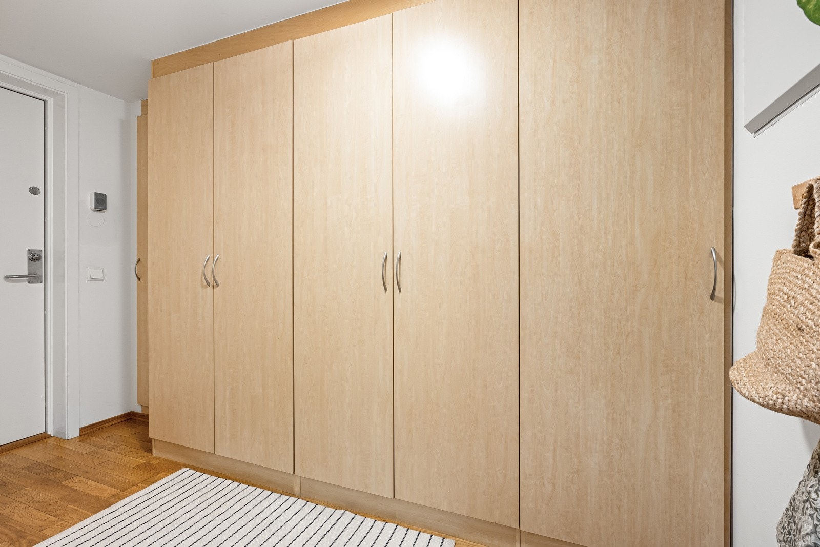 I entreen er det dørcalling og seksdørs garderobeskap med trehvite, glatte fronter. Galleribilde