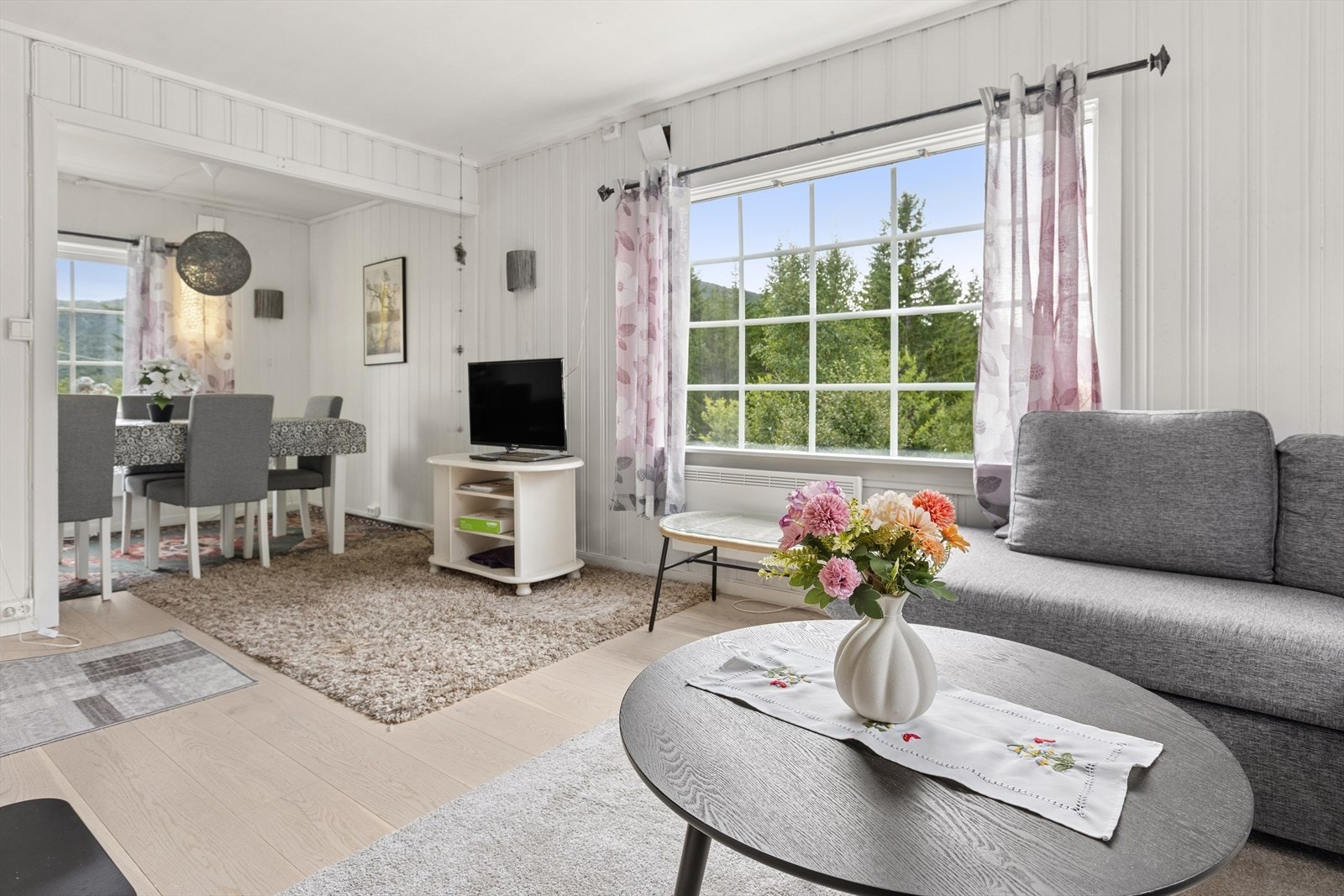 Innbydende stue med lyse overflater og pent enstavs laminatgulv. Galleribilde