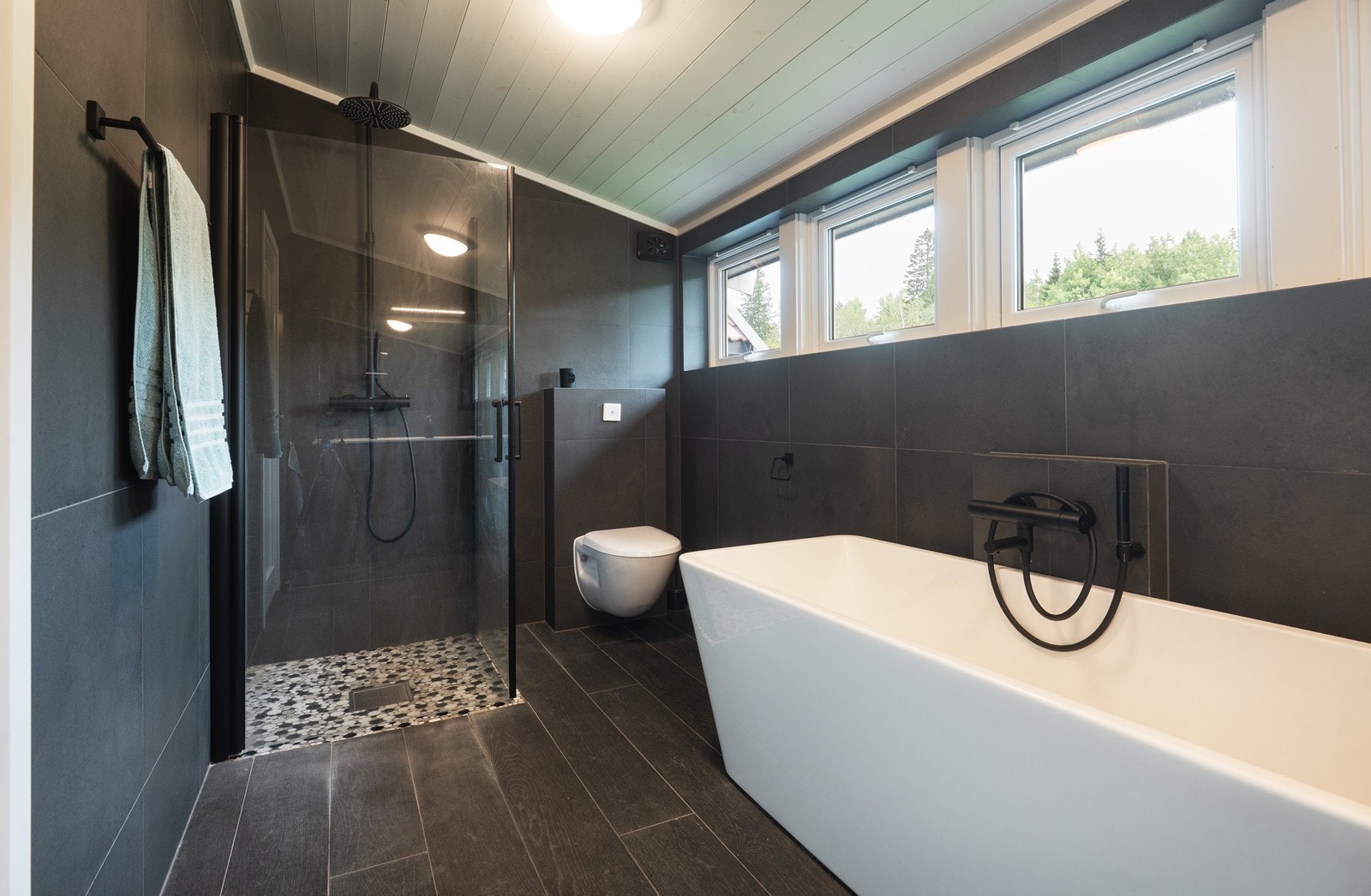 Flott flislagt bad i loftsetasjen med både dusjhjørne og badekar Galleribilde