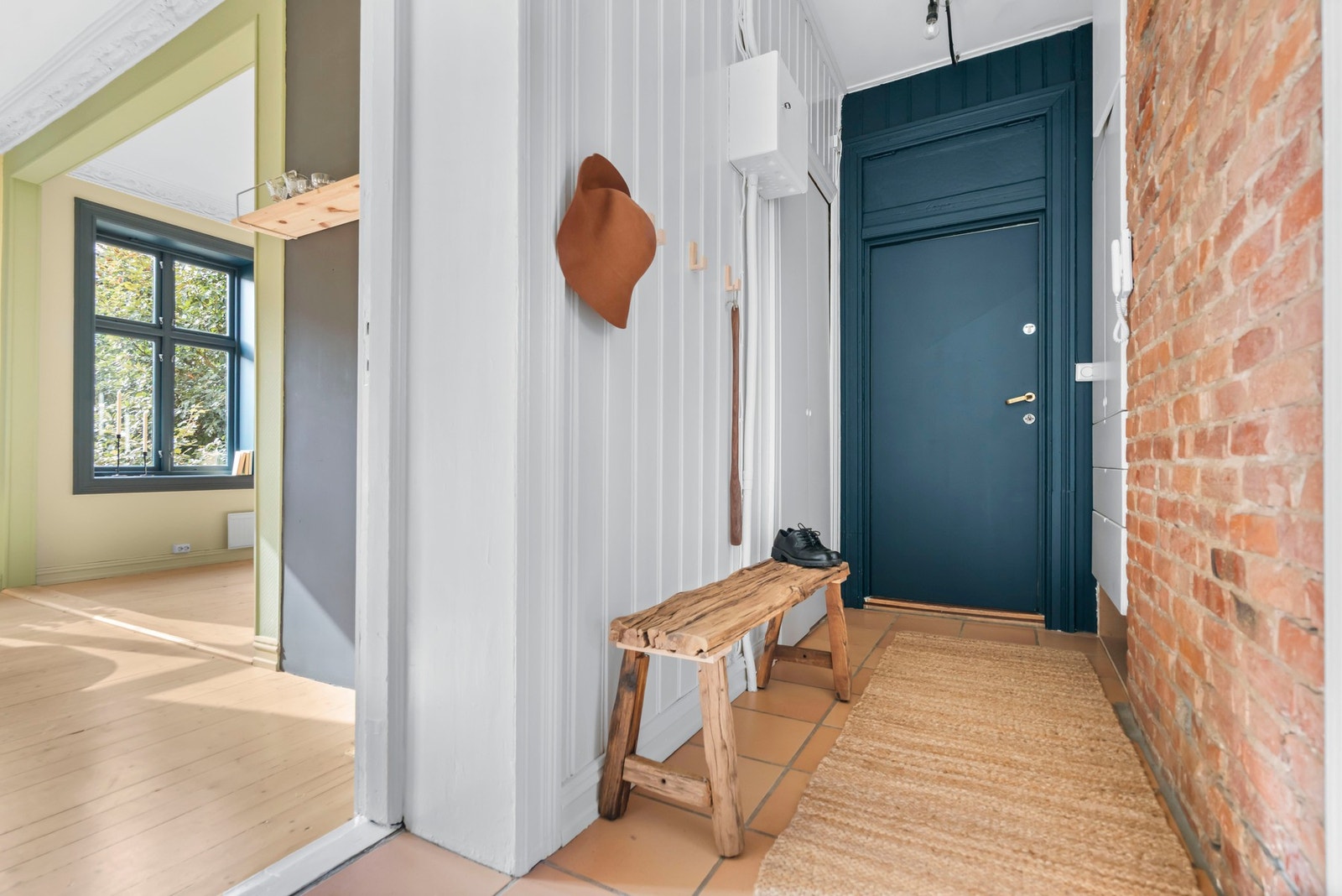 Gangen gir et hyggelig førsteinntrykk med eksponert teglstein og panel på vegger. Ved døren er det rikelig med oppbevaringsplass på begge sider. Galleribilde