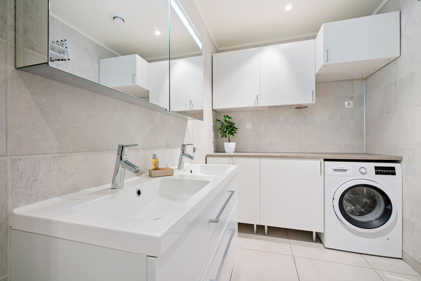 Smart vaskeromsavdeling på badet - med opplegg for vaskemaskin, benkeplate og skap for effektiv klesvask og oppbevaring Galleribilde