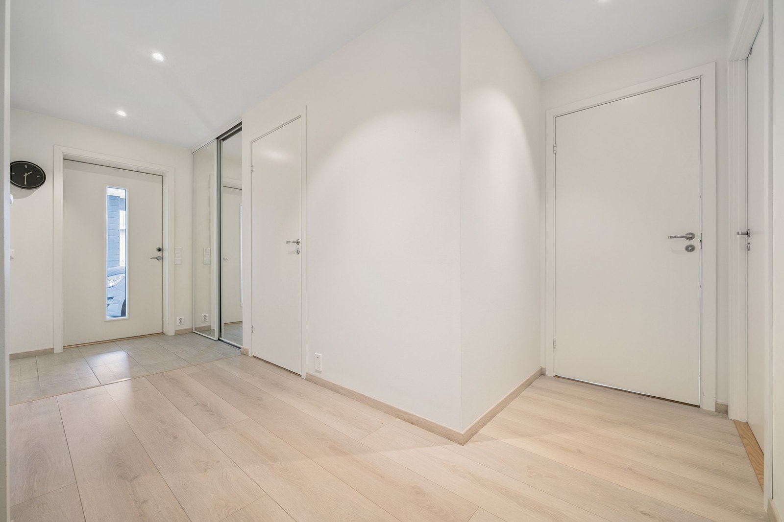 Rett innenfor inngangsdøren er det flislagt gulv med varme og en praktisk skyvedørsgarderobe for oppbevaring av klær og sko Galleribilde