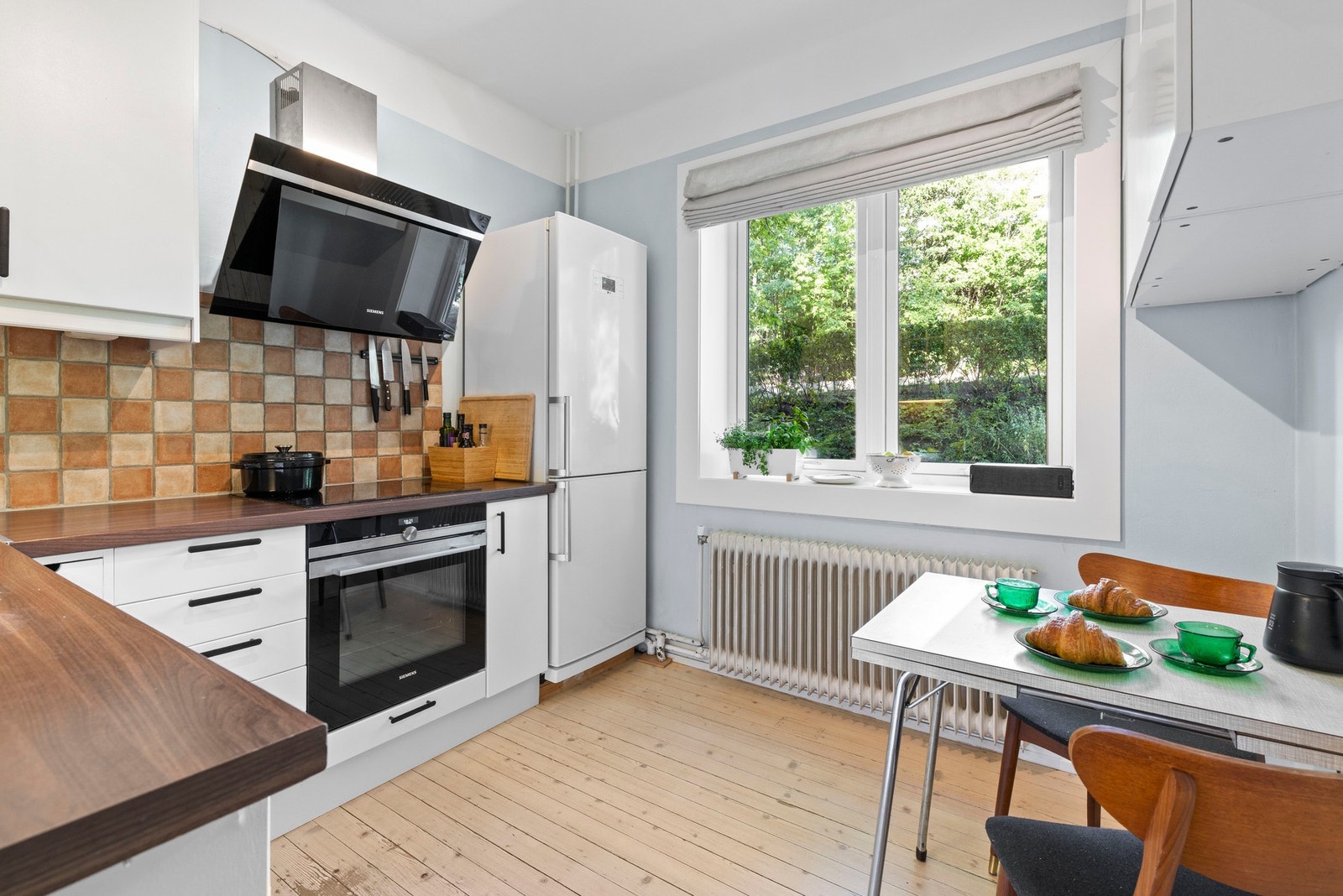 Leilighetens separate kjøkken er både funksjonelt og innbydende, med rikelig skap- og benkeplass og sjarmerende detaljer. Galleribilde