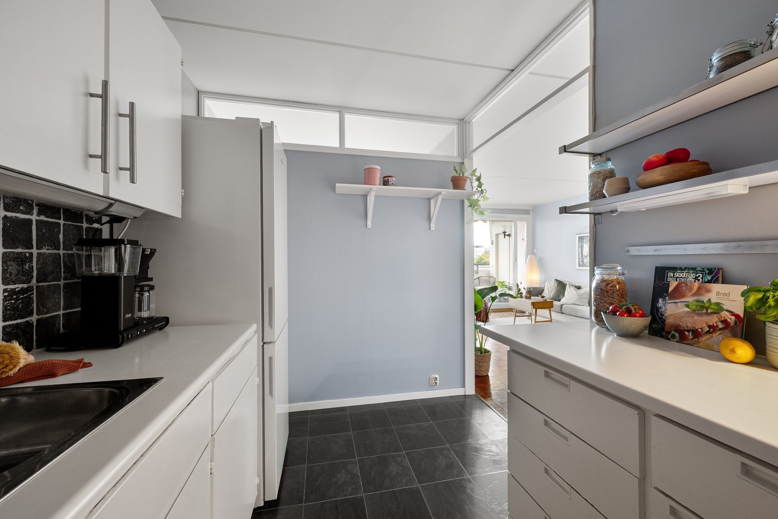 Delvis åpen løsning mellom kjøkken og stue gir en praktisk og sosial utforming, samtidig som rommene har hver sin funksjon. Galleribilde