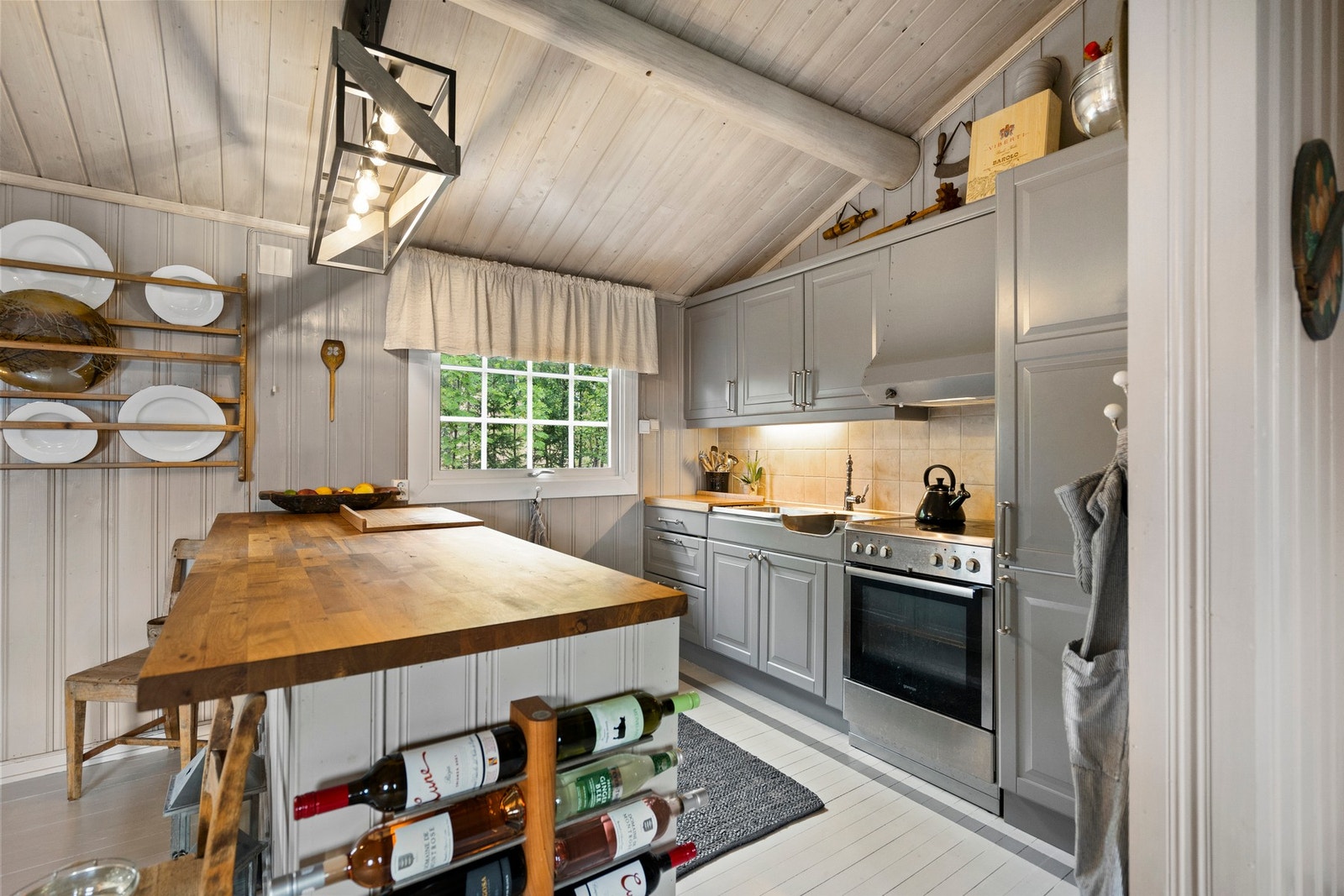 Kjøkkenet med alle hvitevarer samt en pratisk øy mot stuen Galleribilde