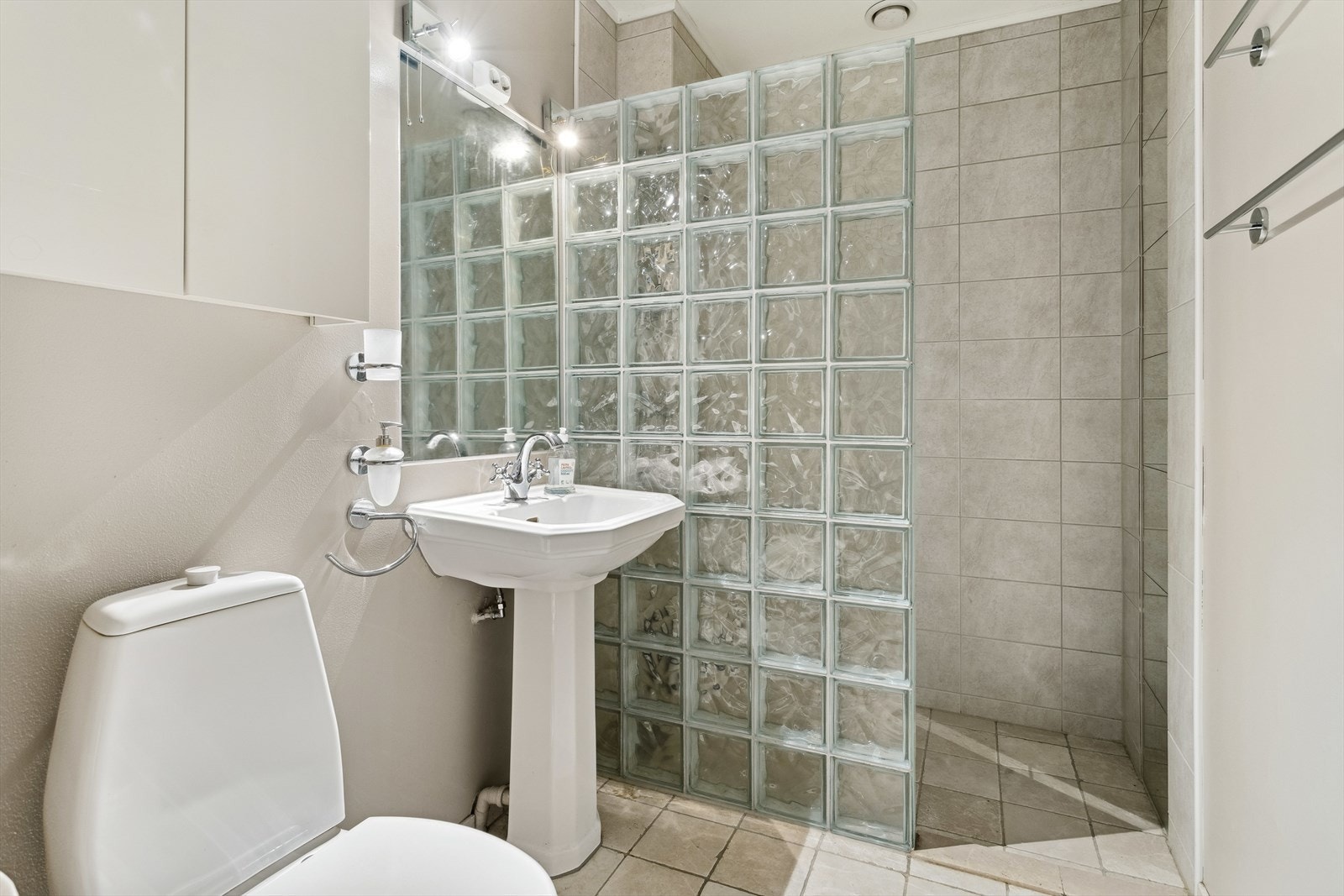 Baderom i hoveddel sokkel har flis på gulv. Flis på vegger i dusjsone, øvrige vegger har slett malte vegger. Takplater i himling. Oppgradert i 2014. Badet har dusjvegger av glass, gulvmontert toalett og gulvstående servant. Galleribilde