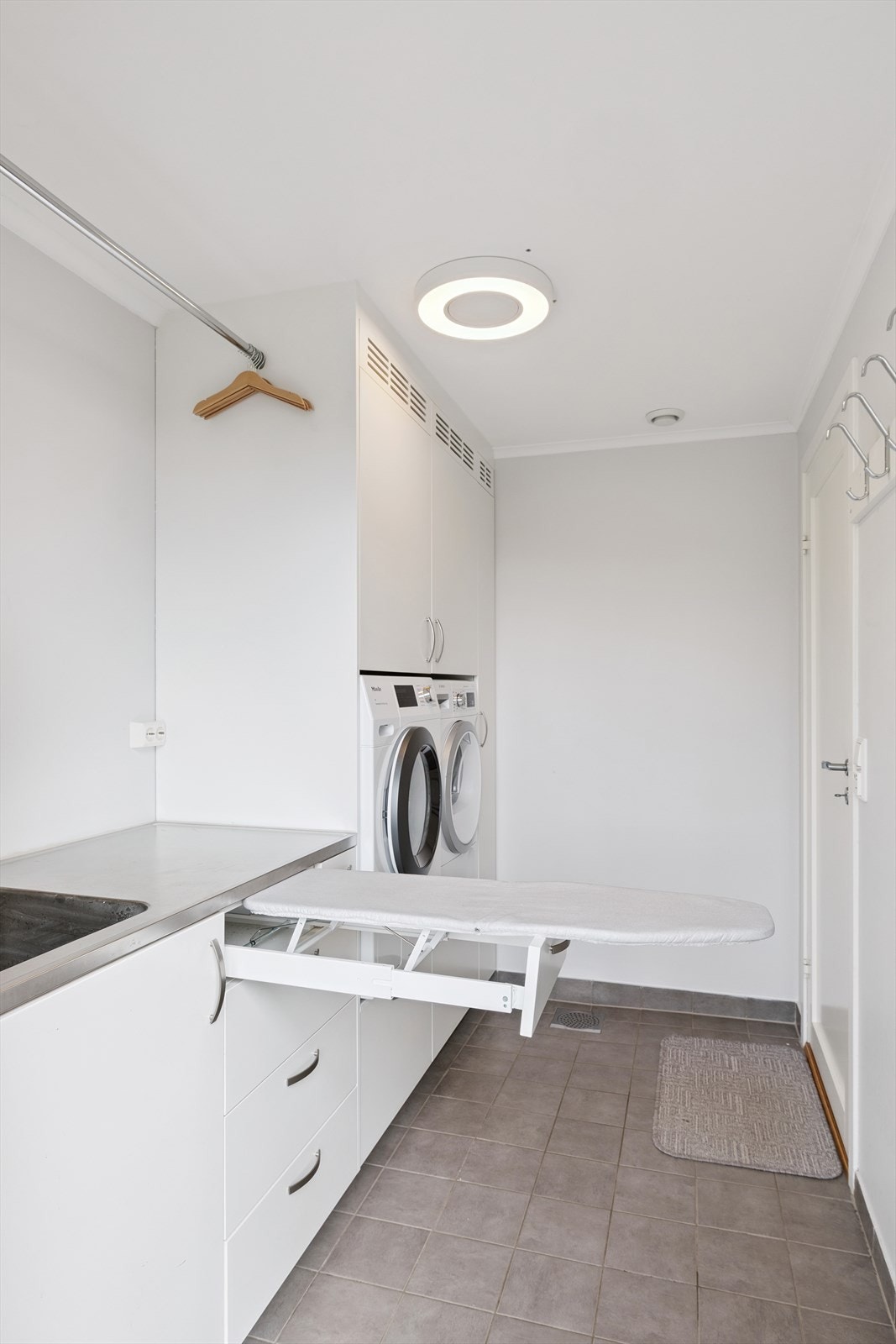 Vaskerom her vist med underskap med integrert strykebrett Galleribilde