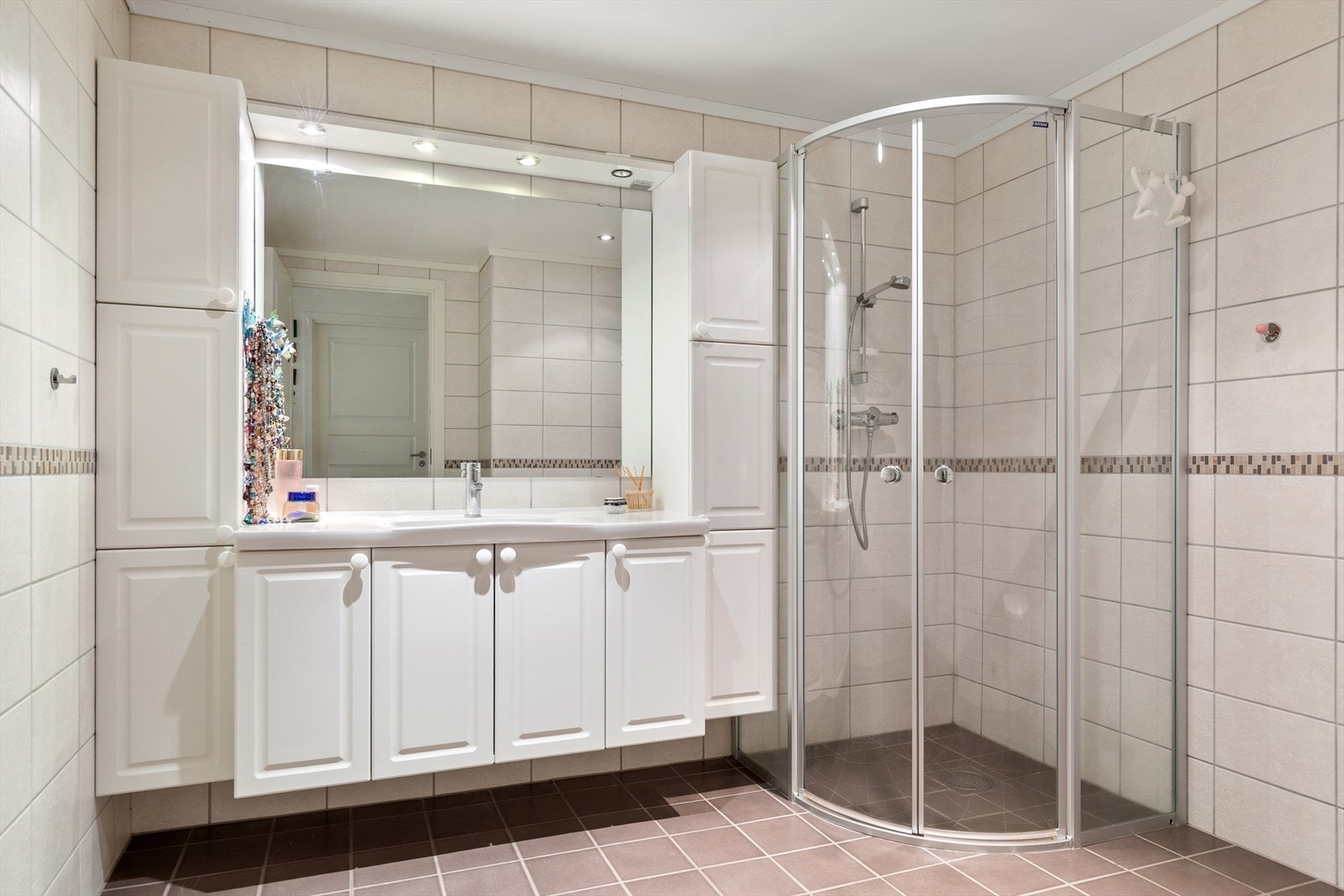 Det er innredet med servantskap med nedfelt servant, stort speil med belysning over samt høyskap på hver side for ekstra oppbevaring. Galleribilde