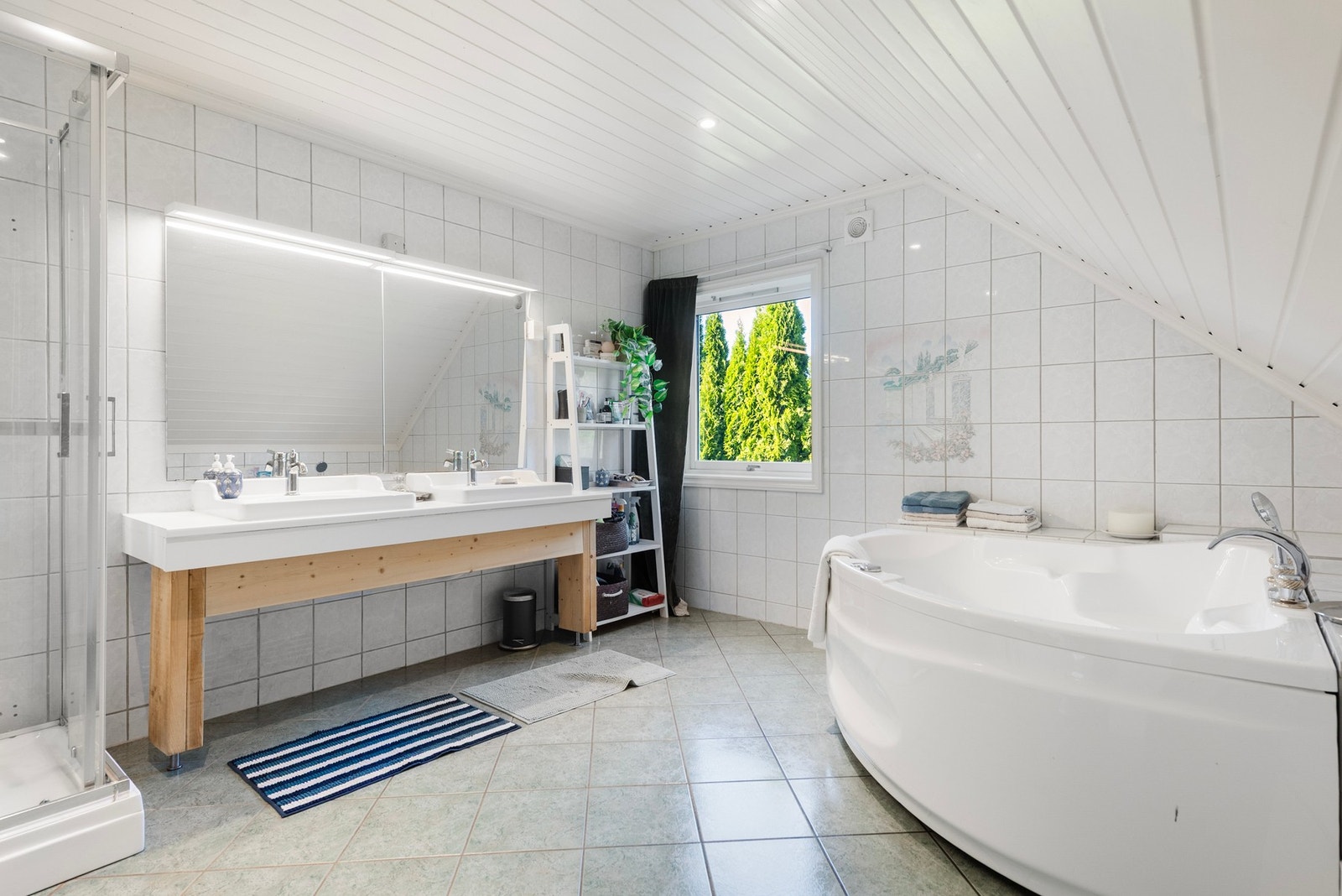 Et romslig bad med stort badekar - til glede for både store og små i familien Galleribilde