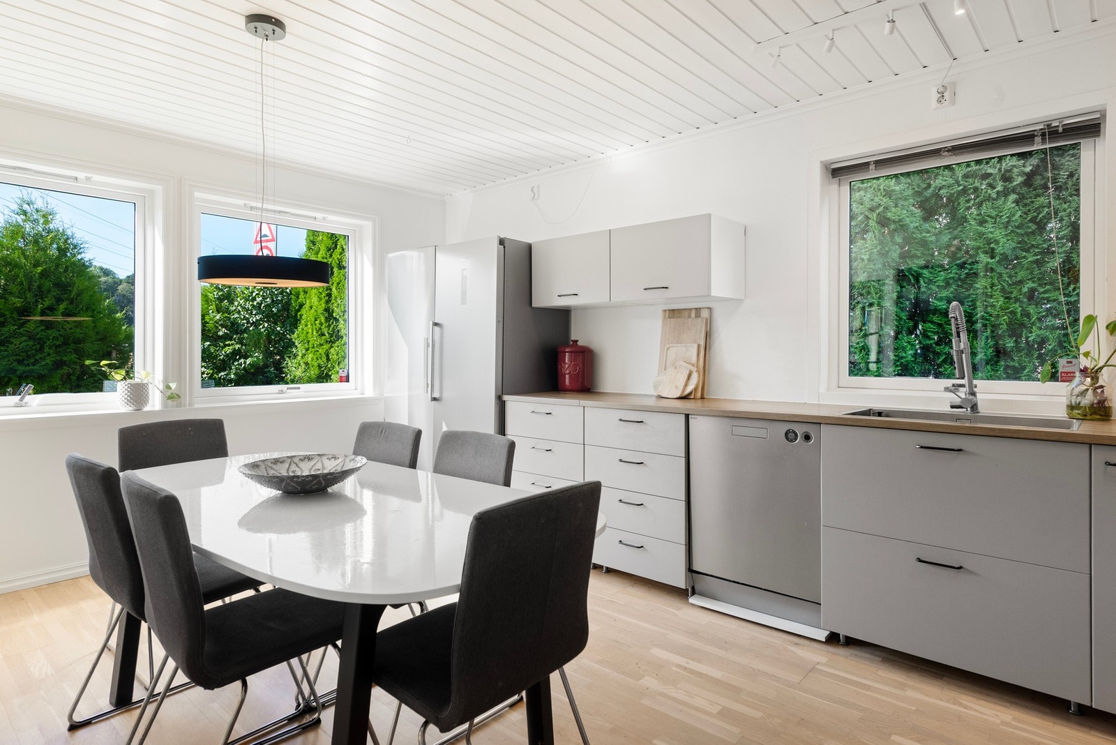 Den lyse opplevelsen av boligen fortsetter inn på kjøkkenet hvor store vindusflater gir rommet rikelig med naturlig lys Galleribilde