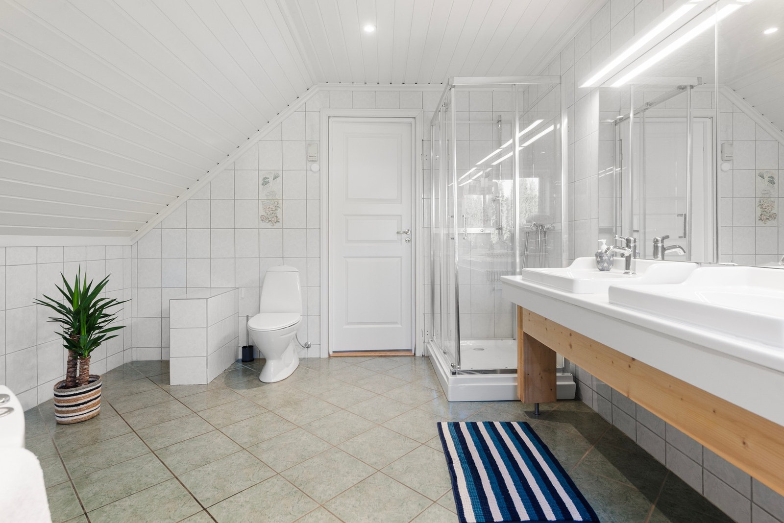 Det romslige badet er utstyrt med dobbel servant, noe som gir god plass og bidrar til en smidig start på dagen uten unødvendig kø i morgentimene Galleribilde