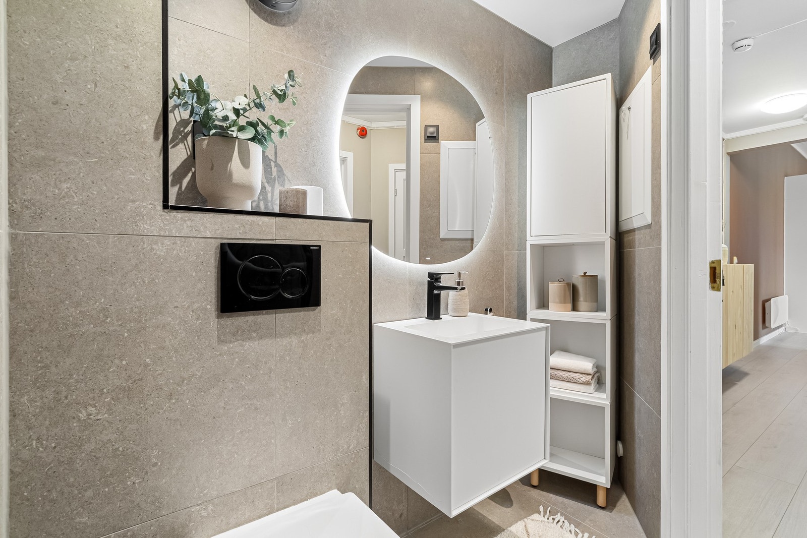 Baderommet har tidsriktige detaljer slik som elegant speil med LED-belysning. Galleribilde