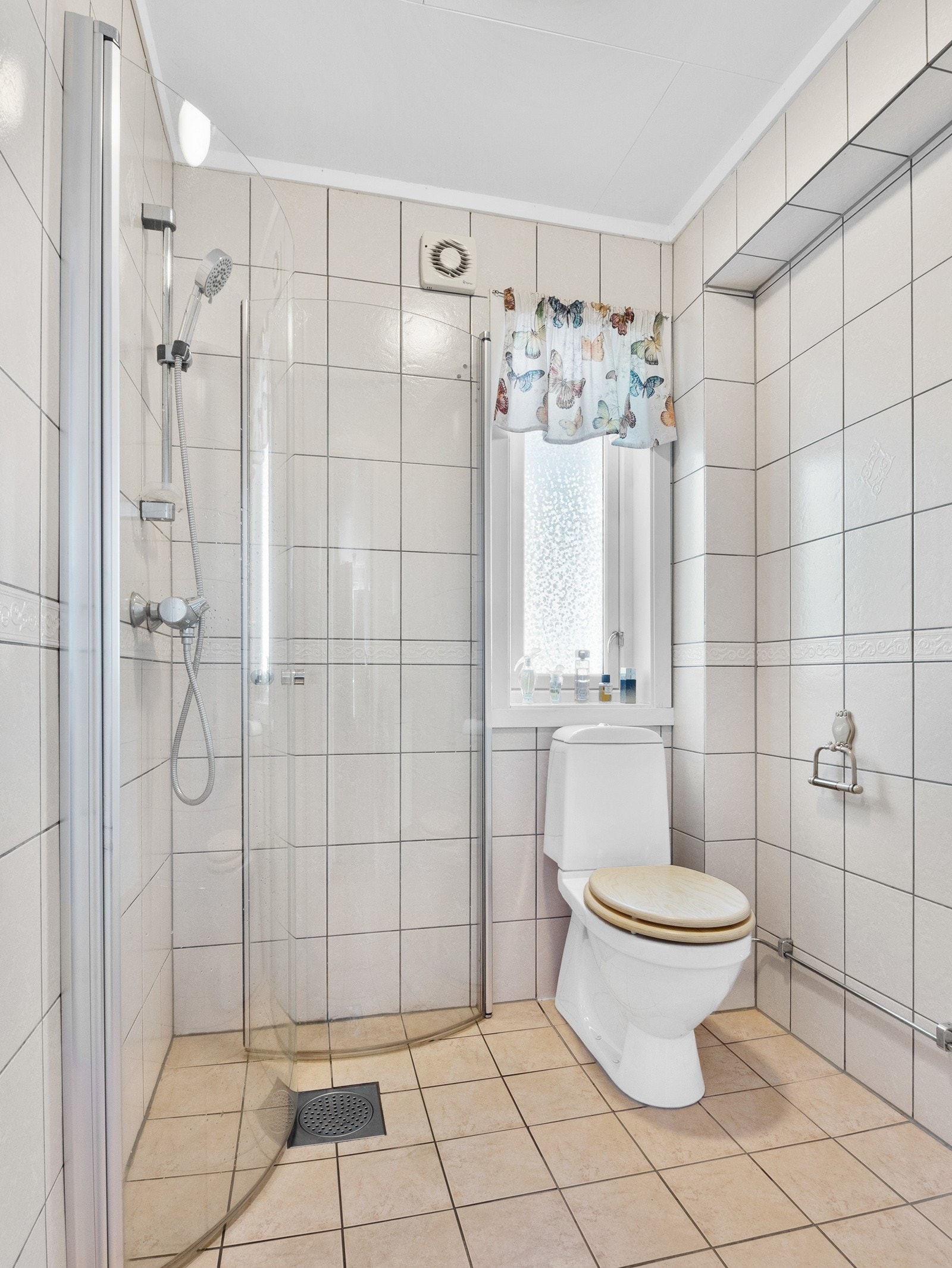 Bad 2 har innredning med servant, dusjhjørne og stående toalett, og det er fliser på vegger og gulv Galleribilde