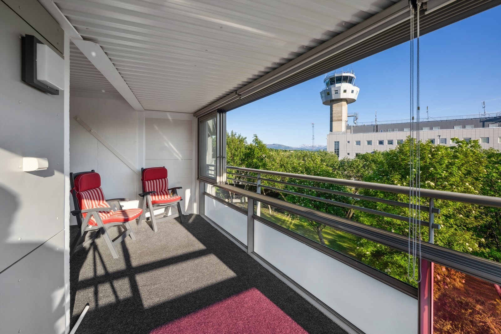 Fra stuen er det utgang til lun og solrik innglasset balkong med teppe på gulvet. Galleribilde