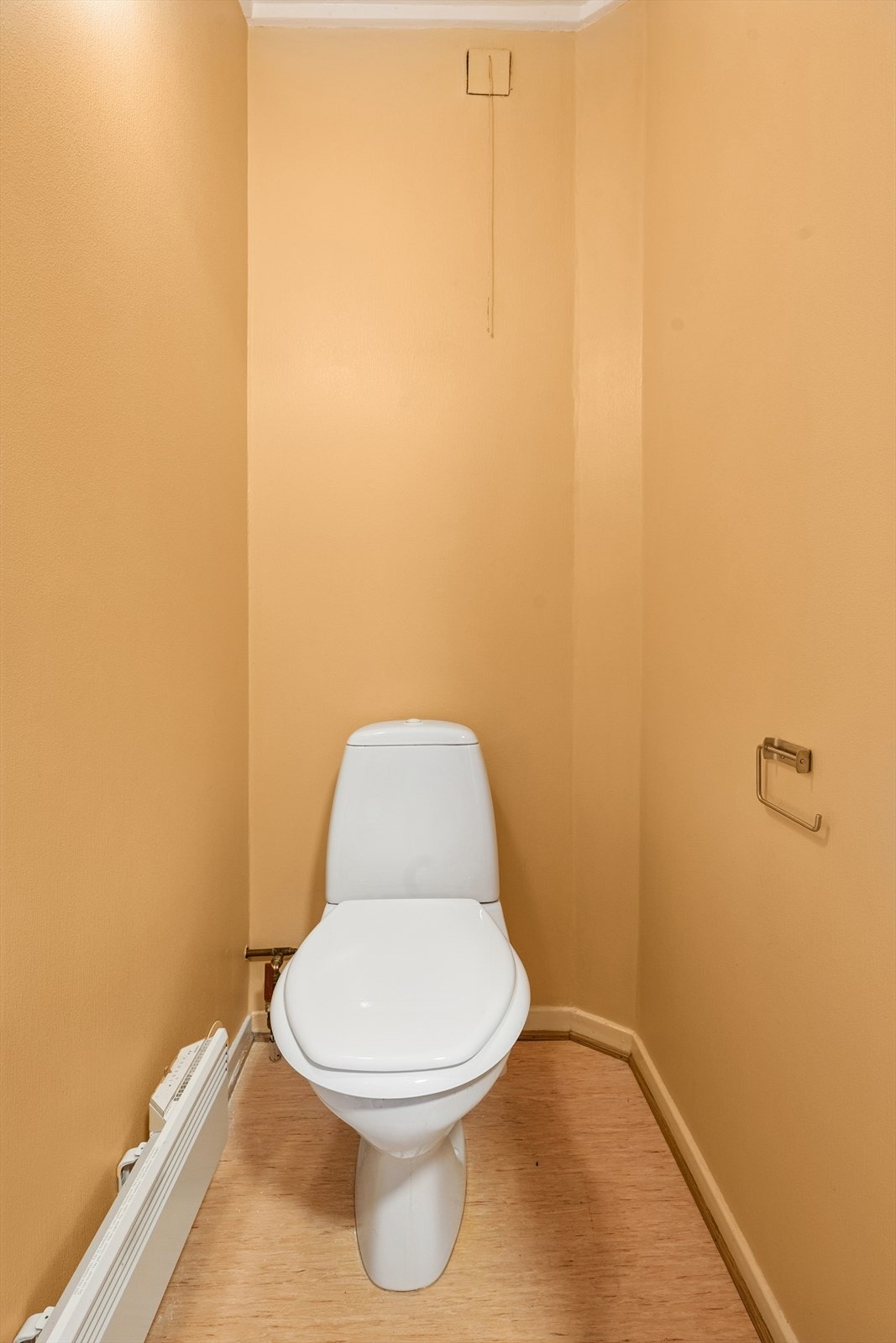 Toalettrom med vinyl på gulv. Malerstrie på vegger. Rommet har gulvstående toalett. Galleribilde