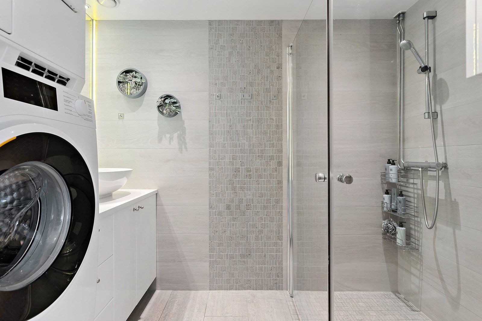 Stort flislagt bad med gulvvarme og downlights. Plass til vaskemaskin og tørketrommel Galleribilde