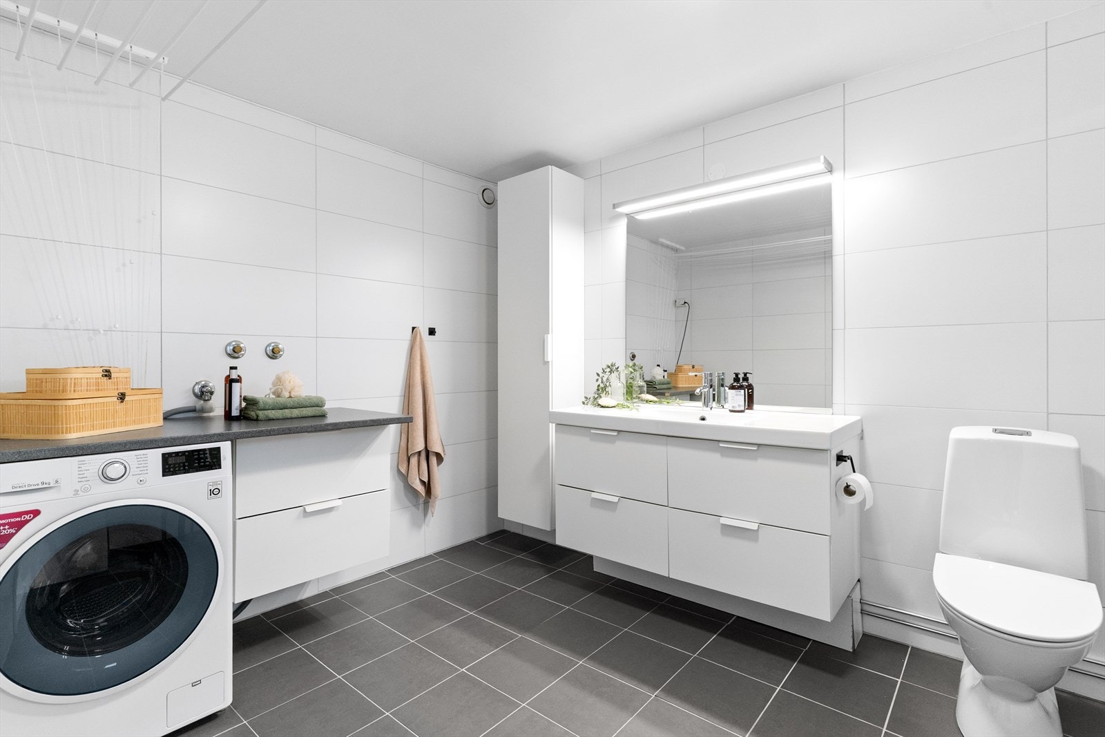 Flislagt bad med varme i gulvet. Innredning med heldekkende vask, skuffer og høyskap. Opplegg til vaskemaskin. Galleribilde