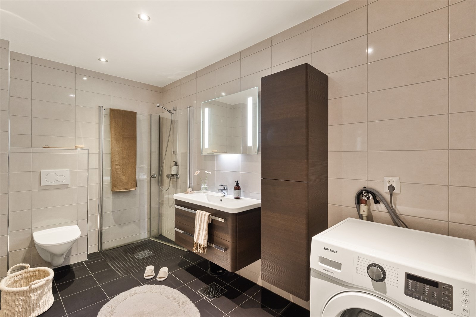 Badet er romslig, pent og moderne, med fliser både på vegger og gulv. Galleribilde