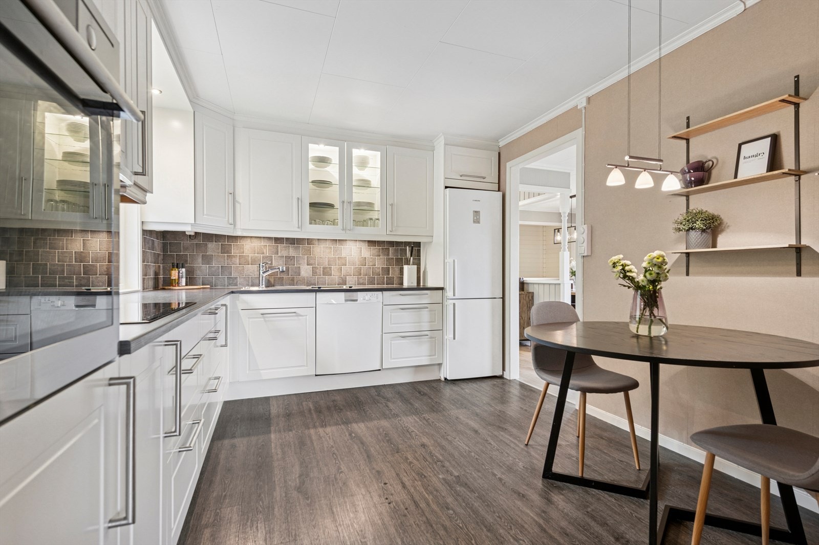 Kjøkkenet fremstår lyst og tidløst med en klassisk innredning bestående av laminerte skrog, profilerte fronter og en laminert benkeplate med kjøkkenkum og blandebatteri. Galleribilde