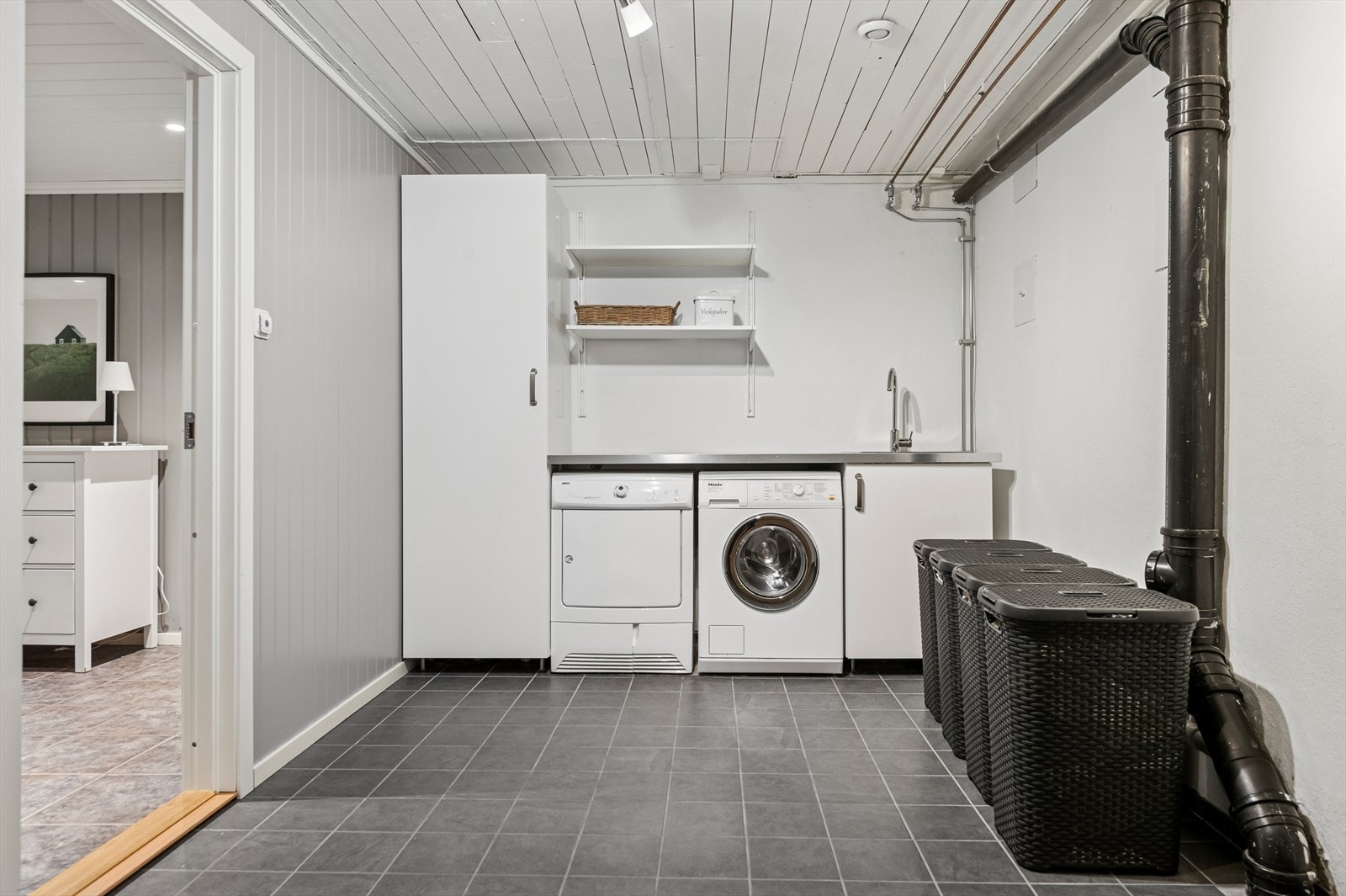 Romslig og funksjonelt vaskerom med god plass til både vaskemaskin og annet vaskeromsutstyr. Galleribilde