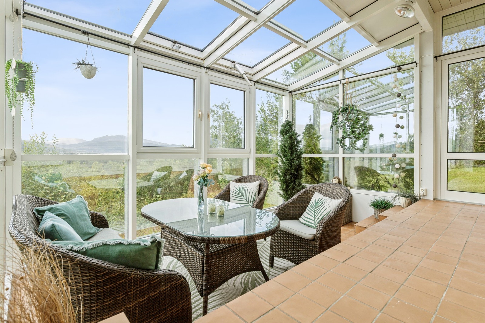 Her kan du nyte morgenkaffen i ly for vær og vind, eller bruke rommet som et ekstra oppholdsrom med nærhet til naturen, og med dør ut til hagen Galleribilde