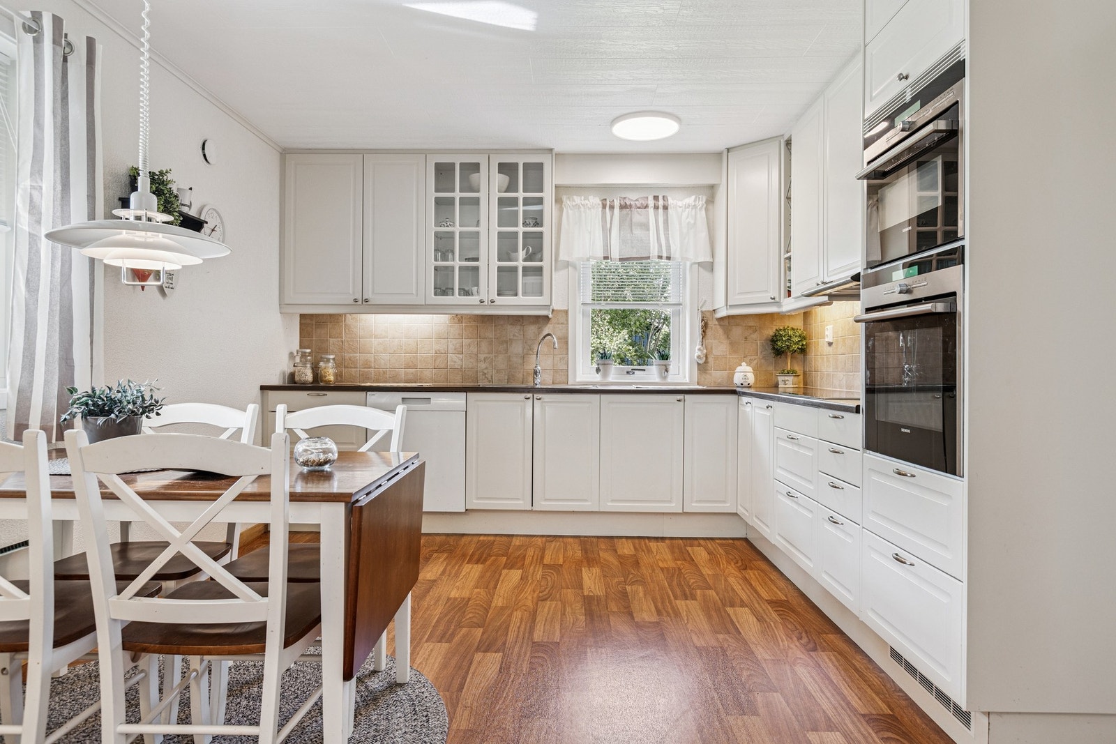 Lekkert kjøkken fra Marbodal med lyse, profilerte fronter, integrerte hvitevarer og god benkeplass Galleribilde