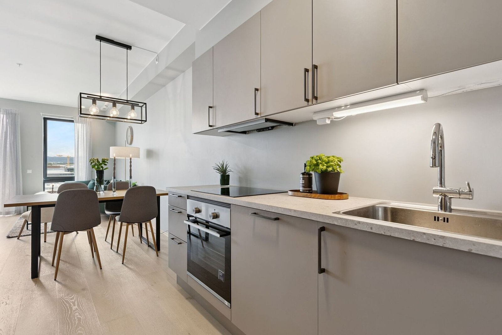 Kjøkkenet har tidsriktige farge- og materialvalg, slette fronter og integrerte hvitevarer. Galleribilde