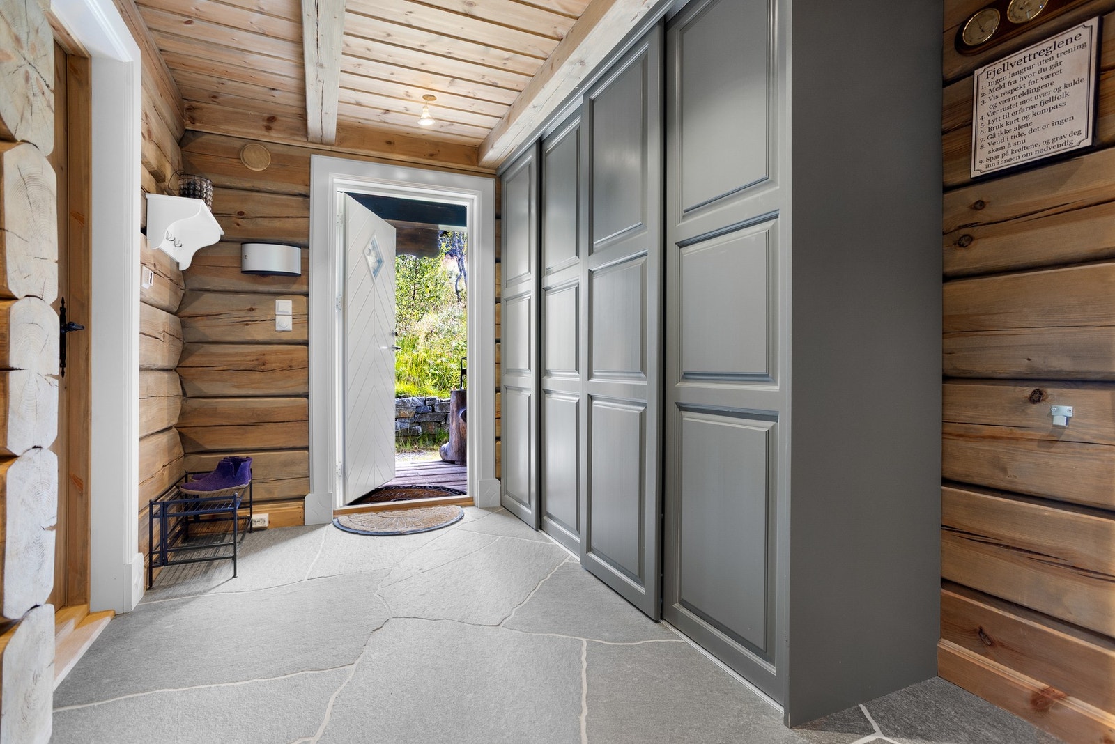 Svært innbydende entré. Her har du skyvedørsgarderobe, med god plass til oppbevaring av yttertøy og sko. Brudden skifer på gulver i gang/entrè og tømmer på vegg Galleribilde