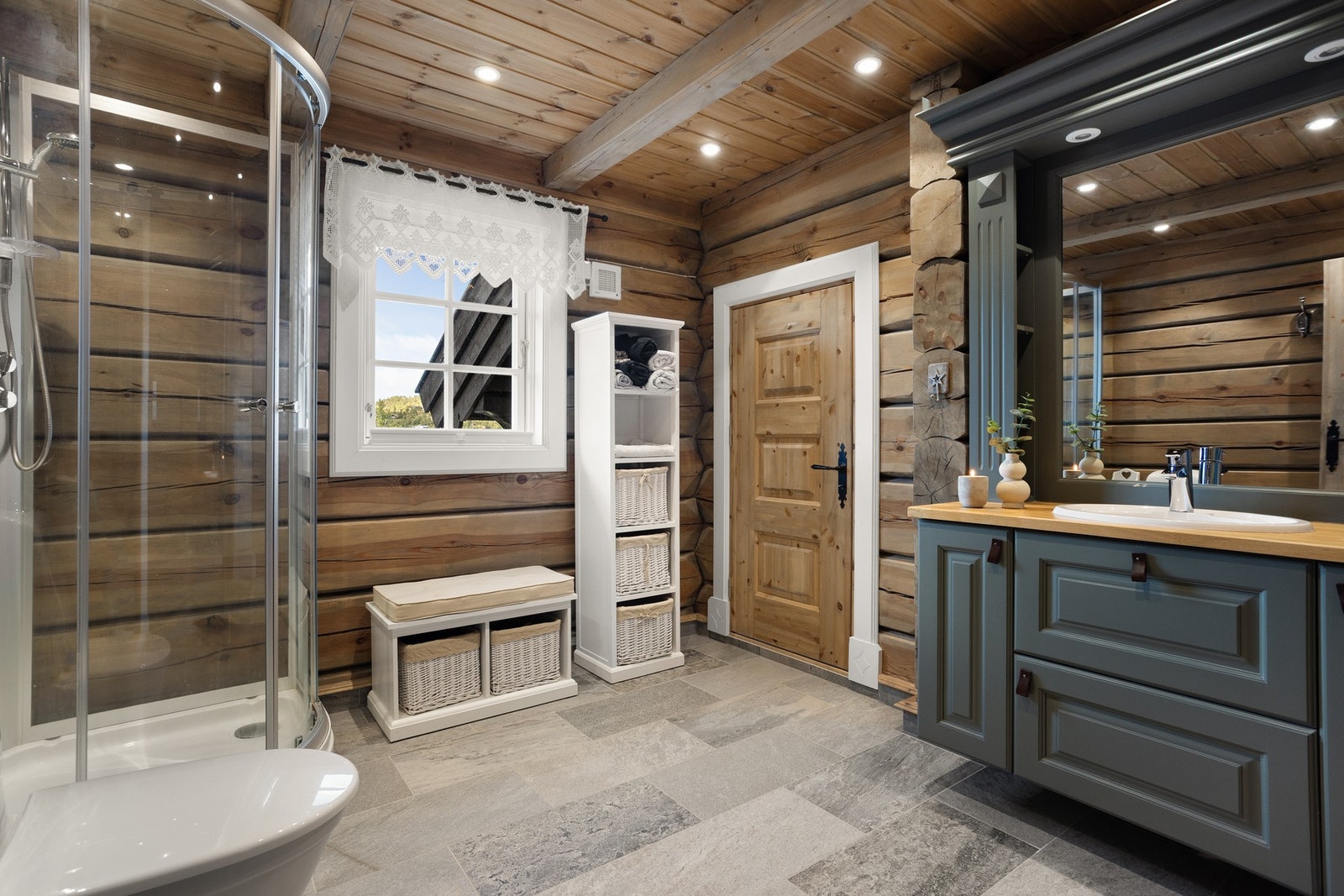 I hyttas 1.etasje finner du 2 bad. Begge baderommene er fint utført med flislagte gulv og laftet tømmer på vegg. Her fra baderom I Galleribilde