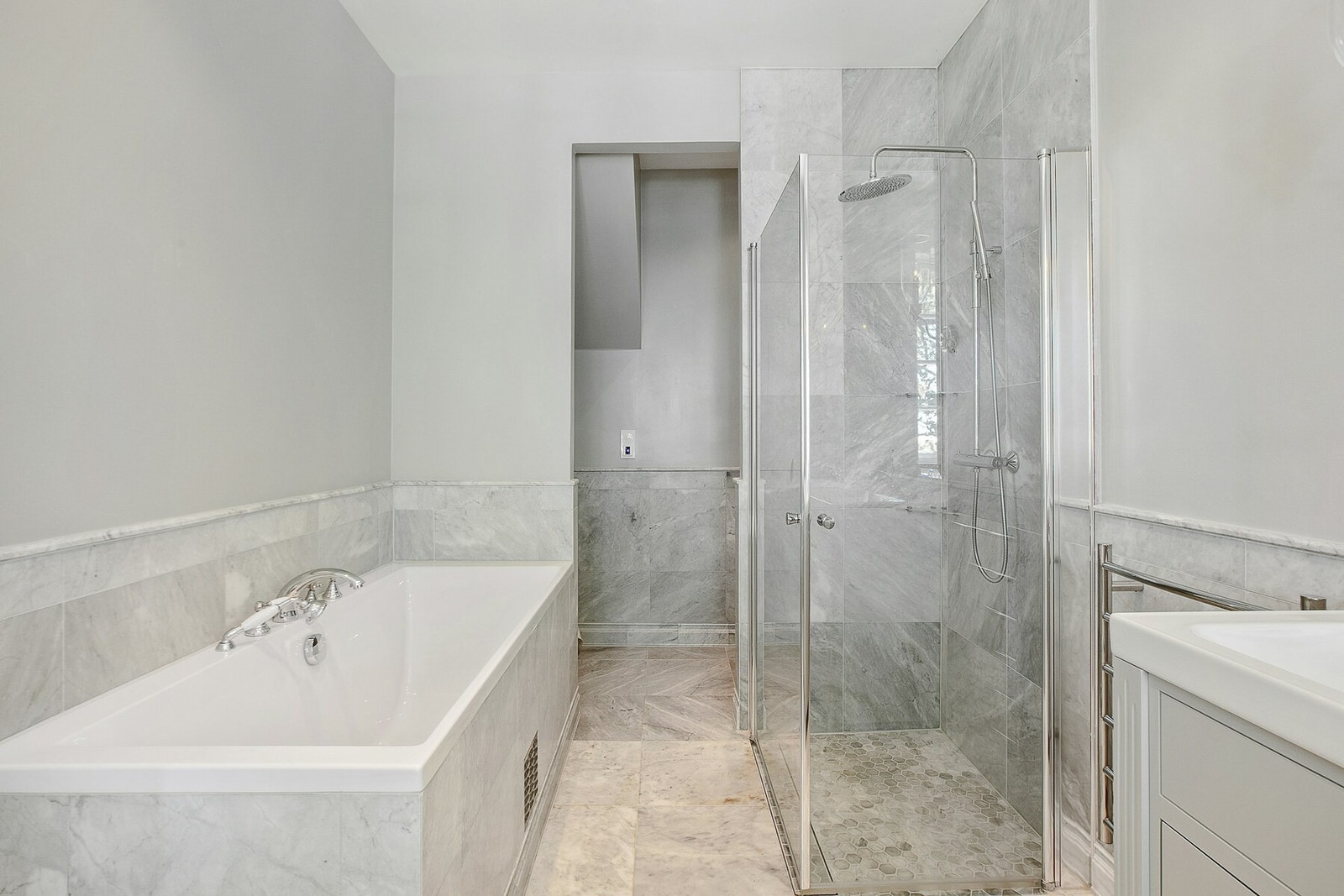 Innmurt badekar, dusj i hjørne med innadslående dører, vegghengt wc og 2 servanter med skuffer under. Det er elektrisk styrt vifte og varmekabler. Galleribilde