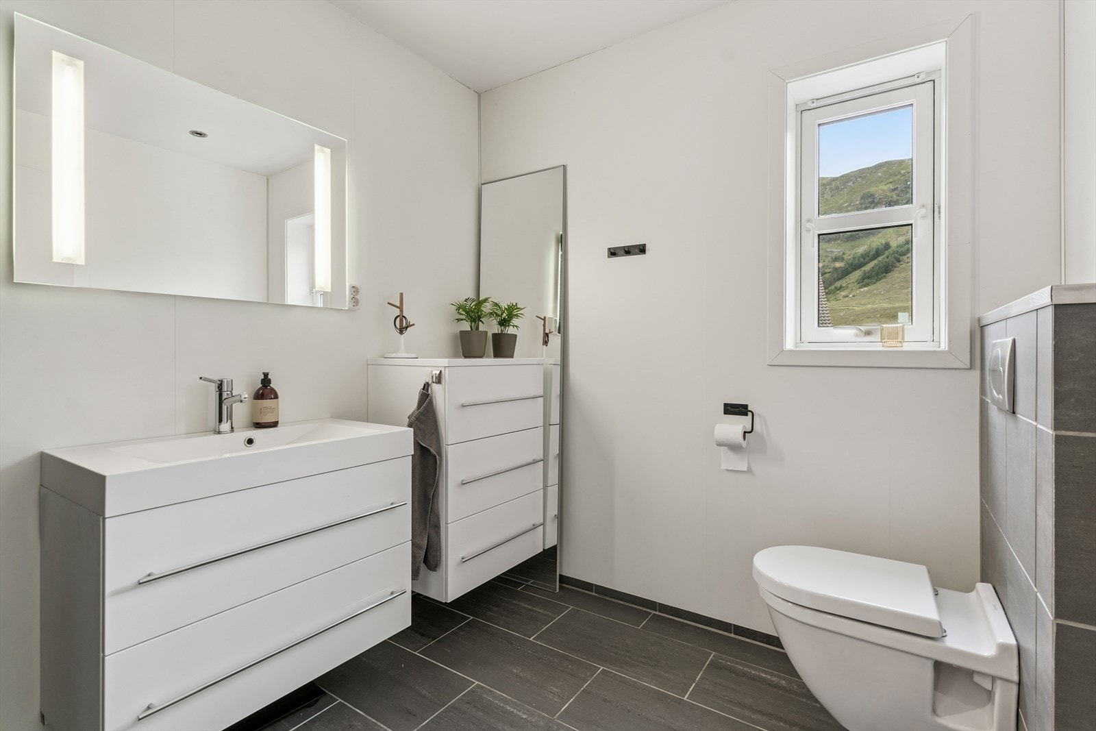 Baderom 2 etasje med vegghengt toalett, servant med innredning og dusj Galleribilde