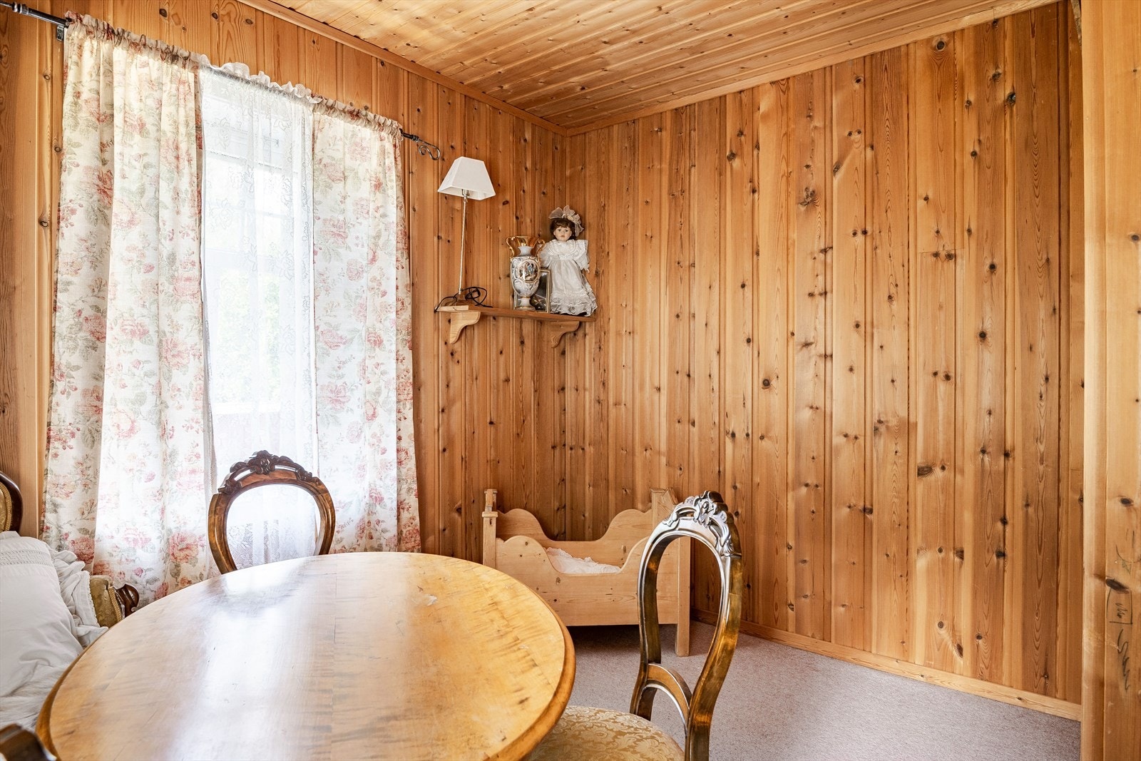 Rommet har lunt teppegulv, panel på veggene og vinduer mot to ulike himmelretninger. Galleribilde