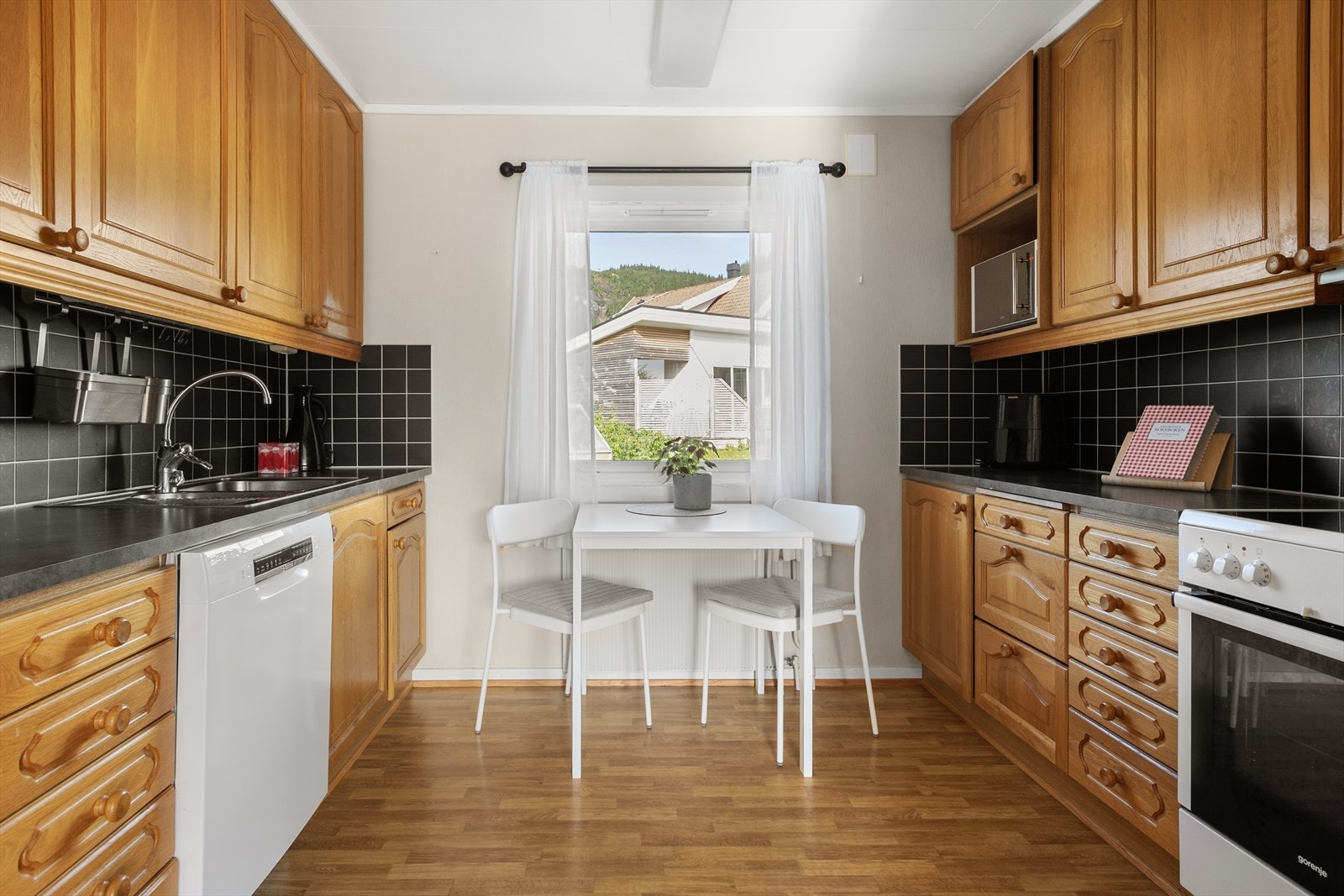 Kjøkkenet har innredning med profilerte fronter og laminert benkeplate. Rikelig med skap og benkeplass. Galleribilde