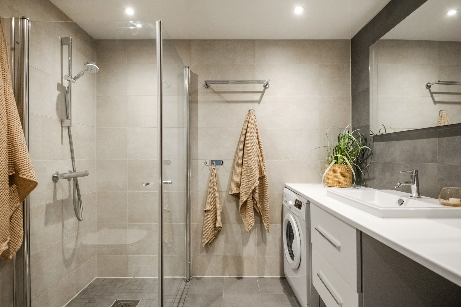 Badet er lekkert og tidløst med flislagte overflater, downlights i himling og varmekabler i gulvet. Galleribilde