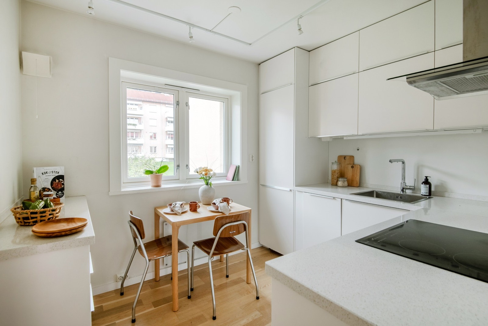 Kjøkkeninnredningen, fra IKEA, fremstår moderne med lyse fronter og benkeplate i stein med kjerne i tre Galleribilde