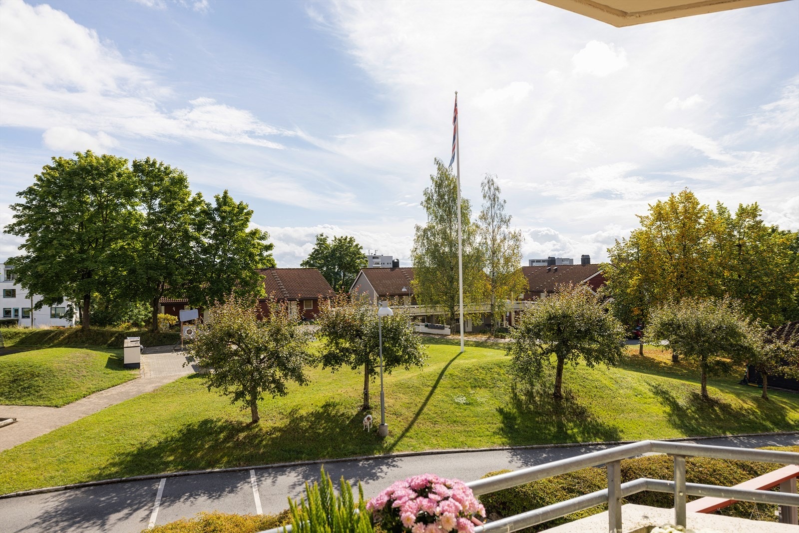 Utsyn fra leiligheten og balkongen mot borettslagets grønne fellesområder. Galleribilde