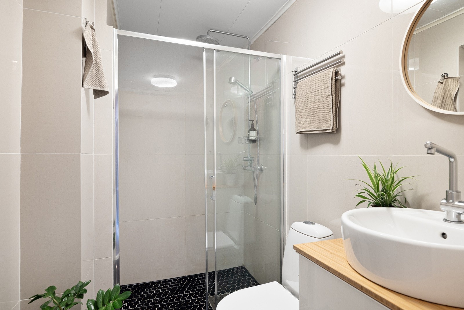 - Pent flislagt bad med dusjnisje med dusjvegger, toalett, servant med skap og speil - Galleribilde