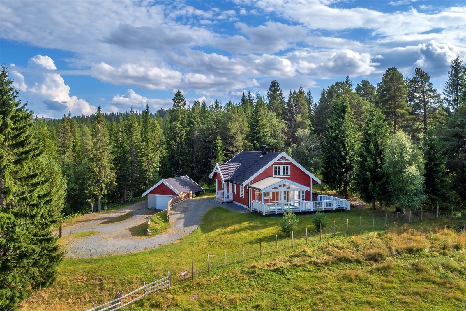 Tomtearealet er terrassert/hellende og delvis opparbeidet med plen, beplantning og støttemurer samt gruset innkjørsel og gårdsplass - For øvrig naturlig vegetasjon Galleribilde