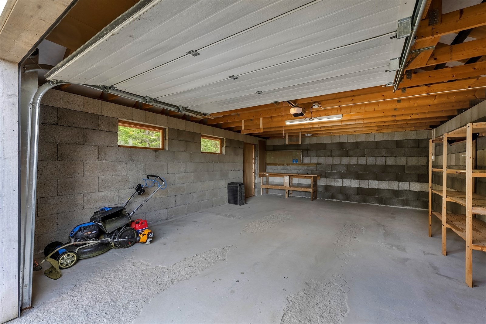 Garasjen har leddport med portåpner og dør i siden Galleribilde