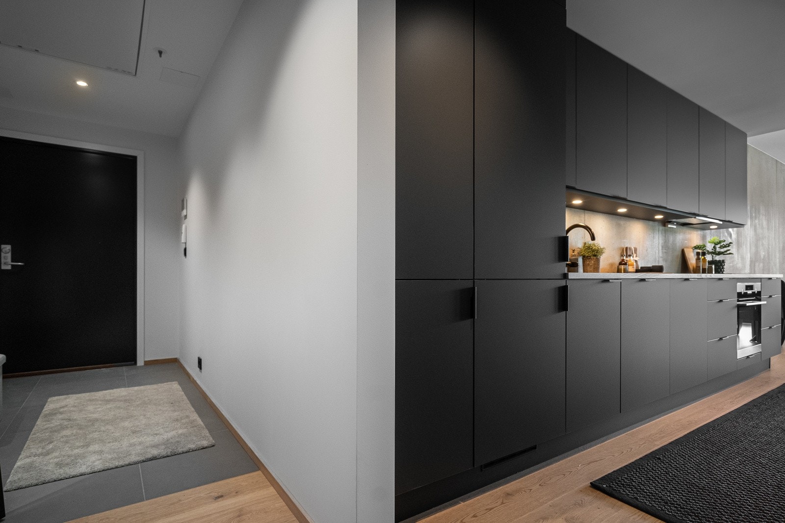 Leiligheten har en meget romslig gang som er flislagt. Her er det også bygd in skyvedørsgarderobe. Galleribilde