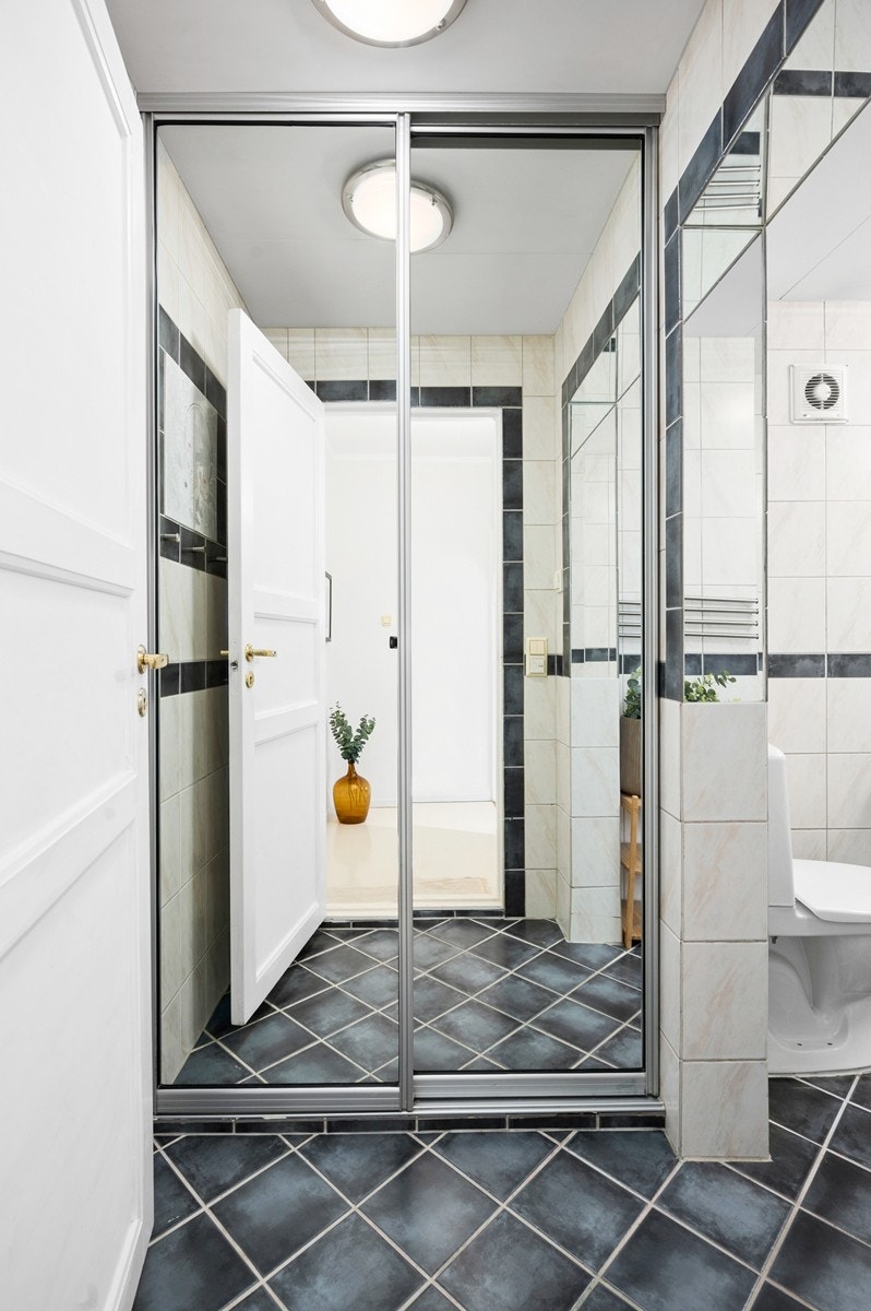 Badet har skyvedørsgarderobe med speilfronter Galleribilde