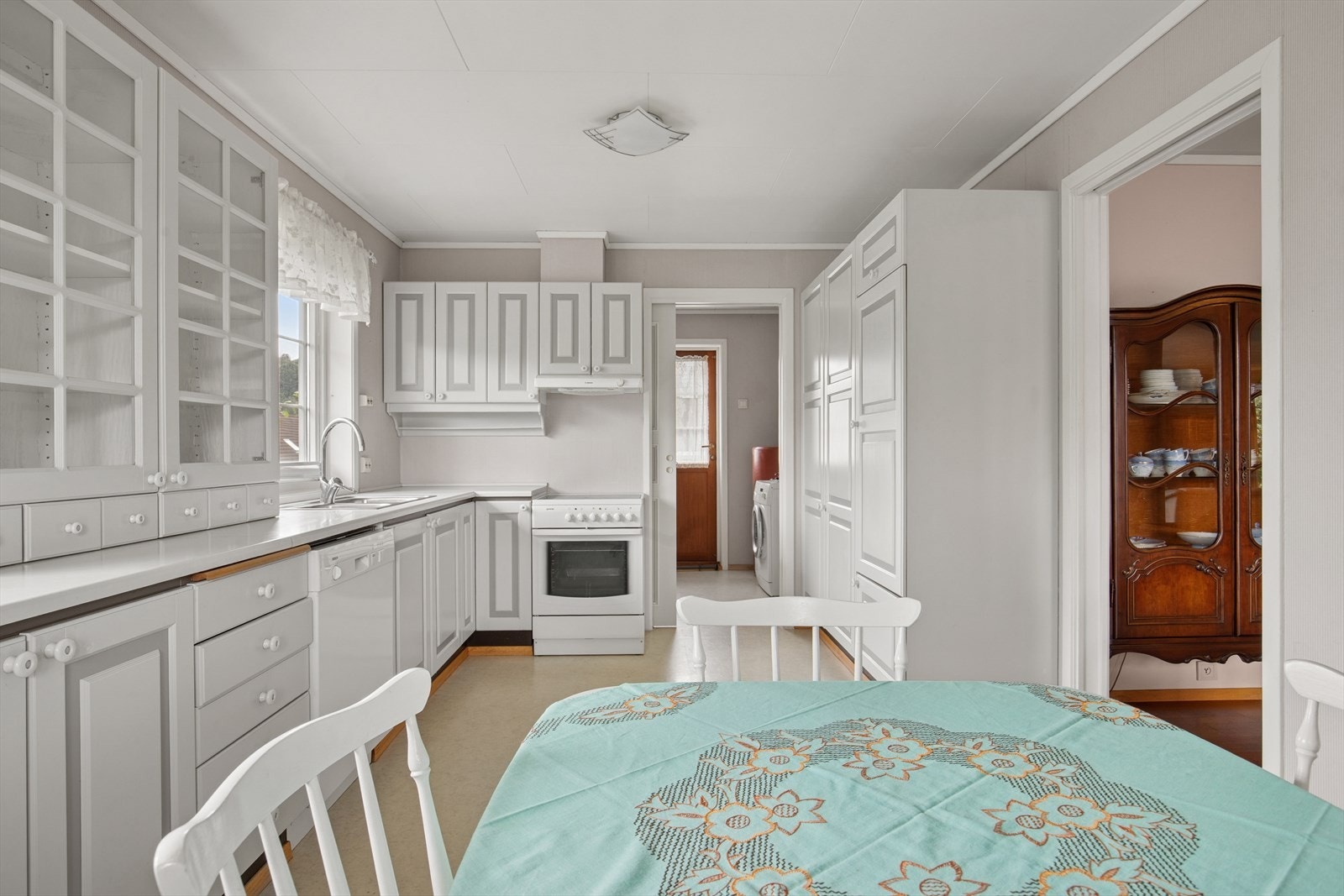 Lyst kjøkken med praktisk utforming og godt med skap- og benkeplass. Galleribilde