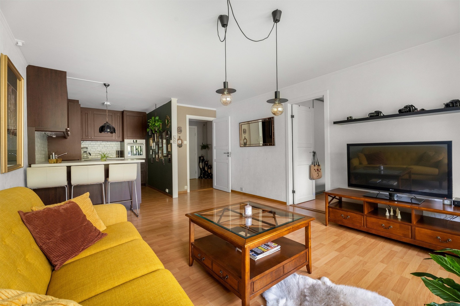 Stuen ligger i åpen løsning med kjøkkenet, og sammen danner de et luftig og innbydende allrom. Galleribilde