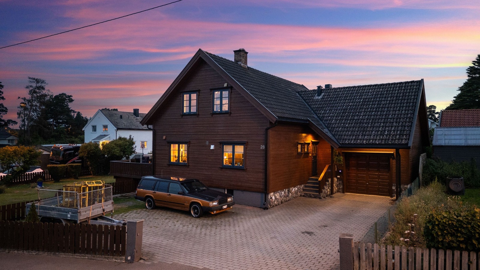 Romslig, stenlagt gårdsplass og garasje i tilknytning til boligen. Galleribilde